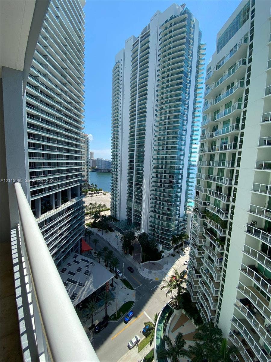 170 SE 14th Street, #2203, Miami, Miami, FL 33131 Elevated balcony featuring a glass-panel railing, overlooking a high-rise urban landscape and waterfront scenery