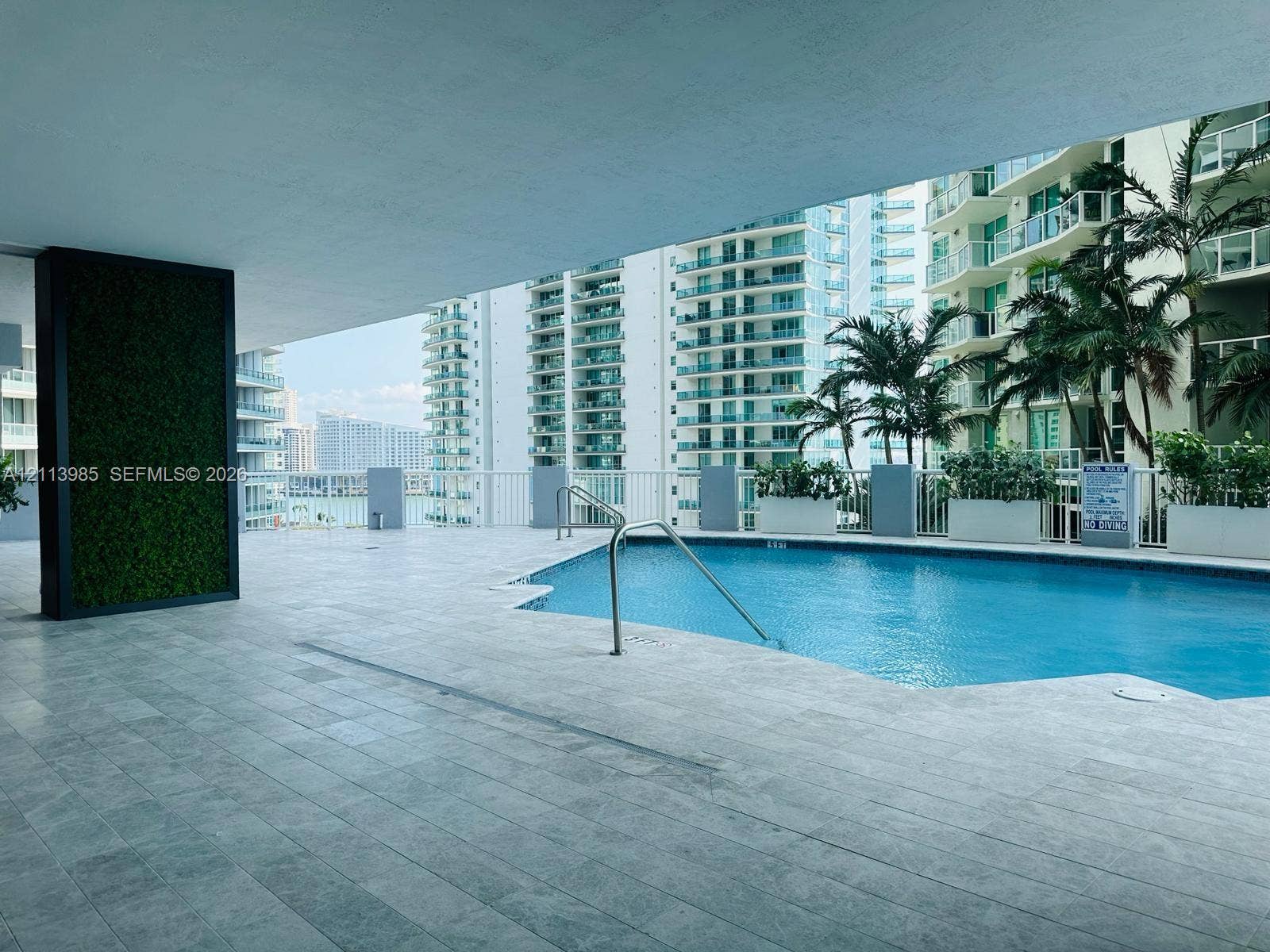170 SE 14th Street, #2203, Miami, Miami, FL 33131 Covered pool deck with stone-tile flooring, metal handrails, integrated greenery wall, and built-in perimeter planters