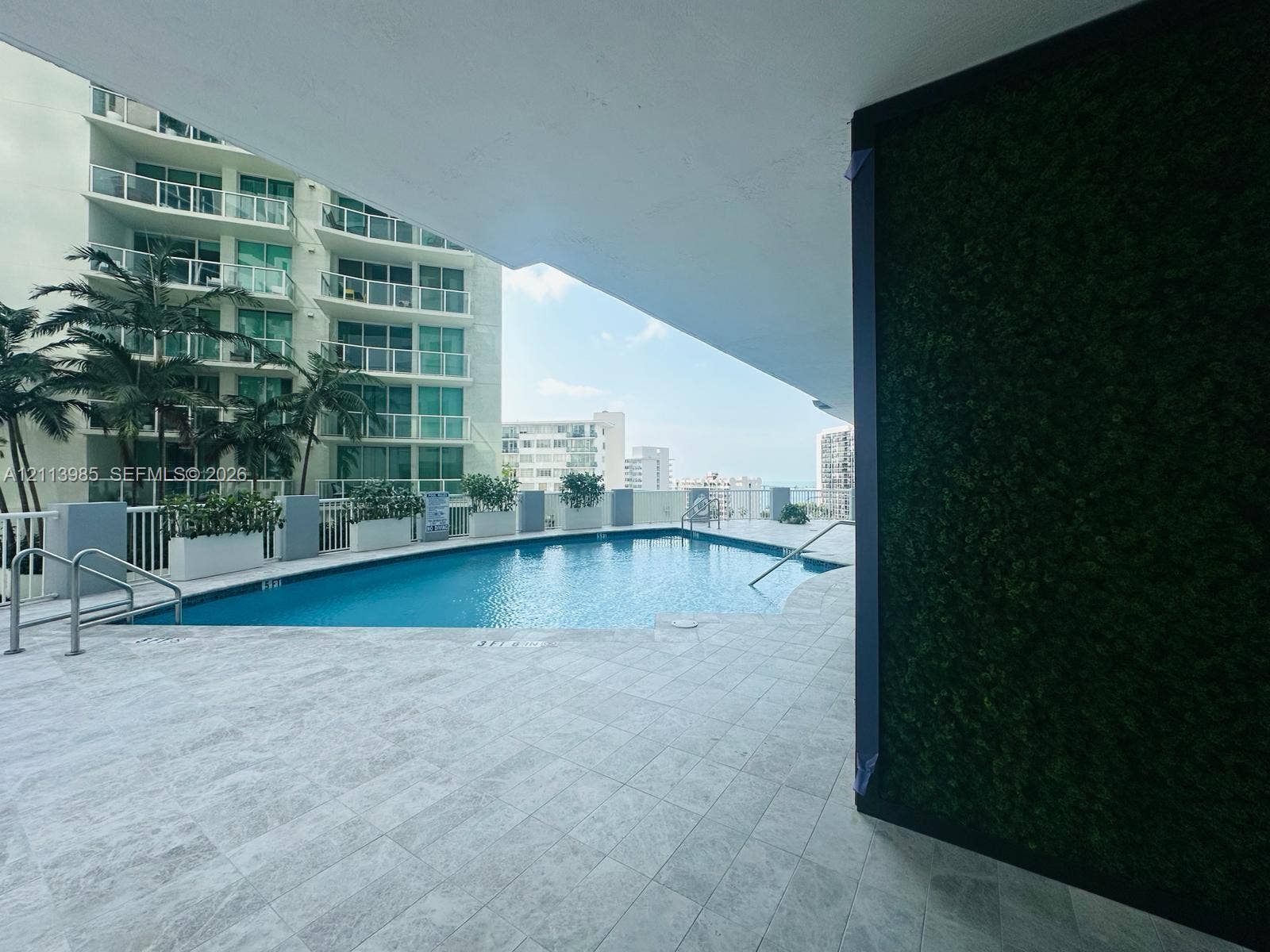170 SE 14th Street, #2203, Miami, Miami, FL 33131 Outdoor swimming pool featuring stone-finish decking, vertical garden wall, and metal safety railings