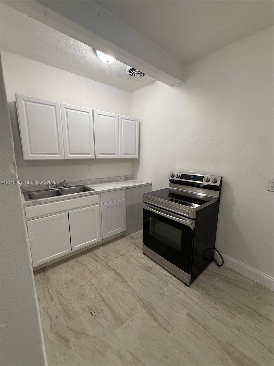 4428 Friden Drive, #4428, Jacksonville, Jacksonville, FL 32209 Kitchen featuring white shaker-style cabinetry, stone-patterned countertops, a stainless steel dual-basin sink, a stainless steel electric range, and light-toned tile flooring