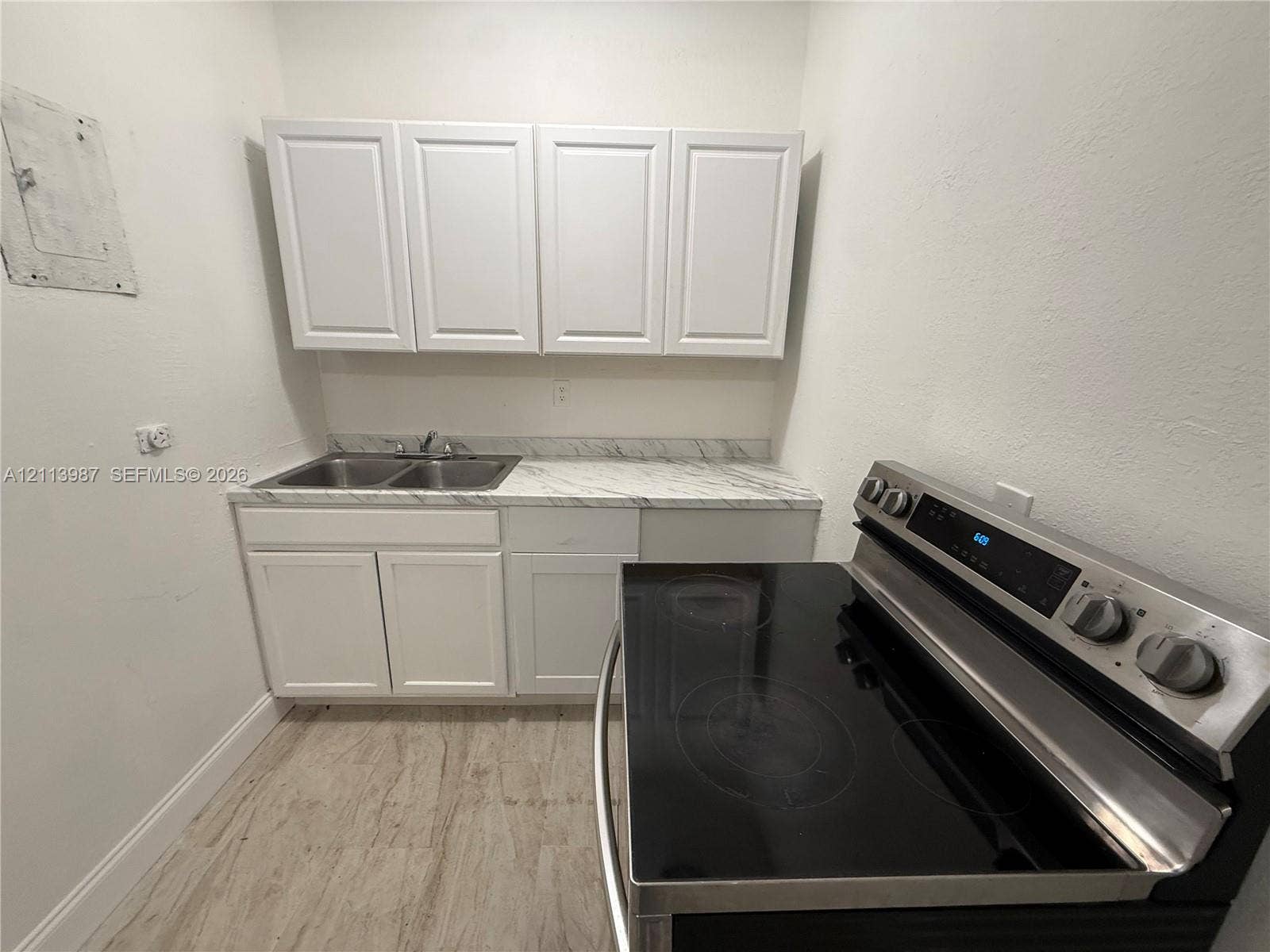 4428 Friden Drive, #4428, Jacksonville, Jacksonville, FL 32209 Kitchen featuring white shaker-style cabinetry, stone-patterned laminate countertops, a dual-basin stainless steel sink, wood-finish flooring, and a stainless steel electric range