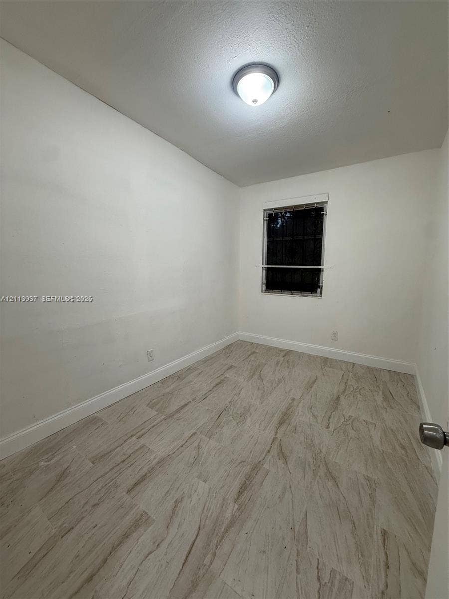 4428 Friden Drive, #4428, Jacksonville, Jacksonville, FL 32209 Neutral-toned wood-finish flooring, white walls, and a single-light flush mount ceiling fixture
