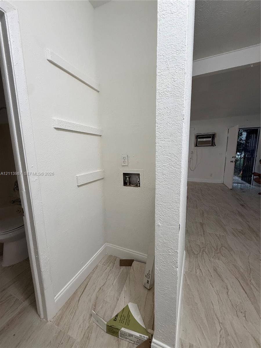 4428 Friden Drive, #4428, Jacksonville, Jacksonville, FL 32209 Dedicated laundry nook featuring wood-finish flooring, built-in shelving, and utility hookups