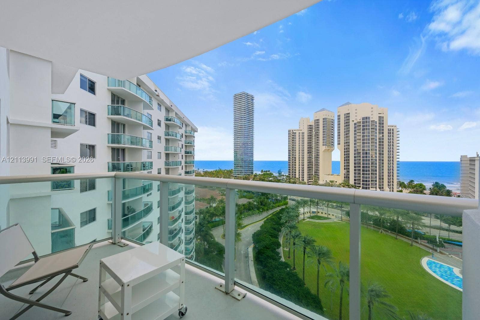 Private balcony featuring glass panel railings and expansive overhead coverage