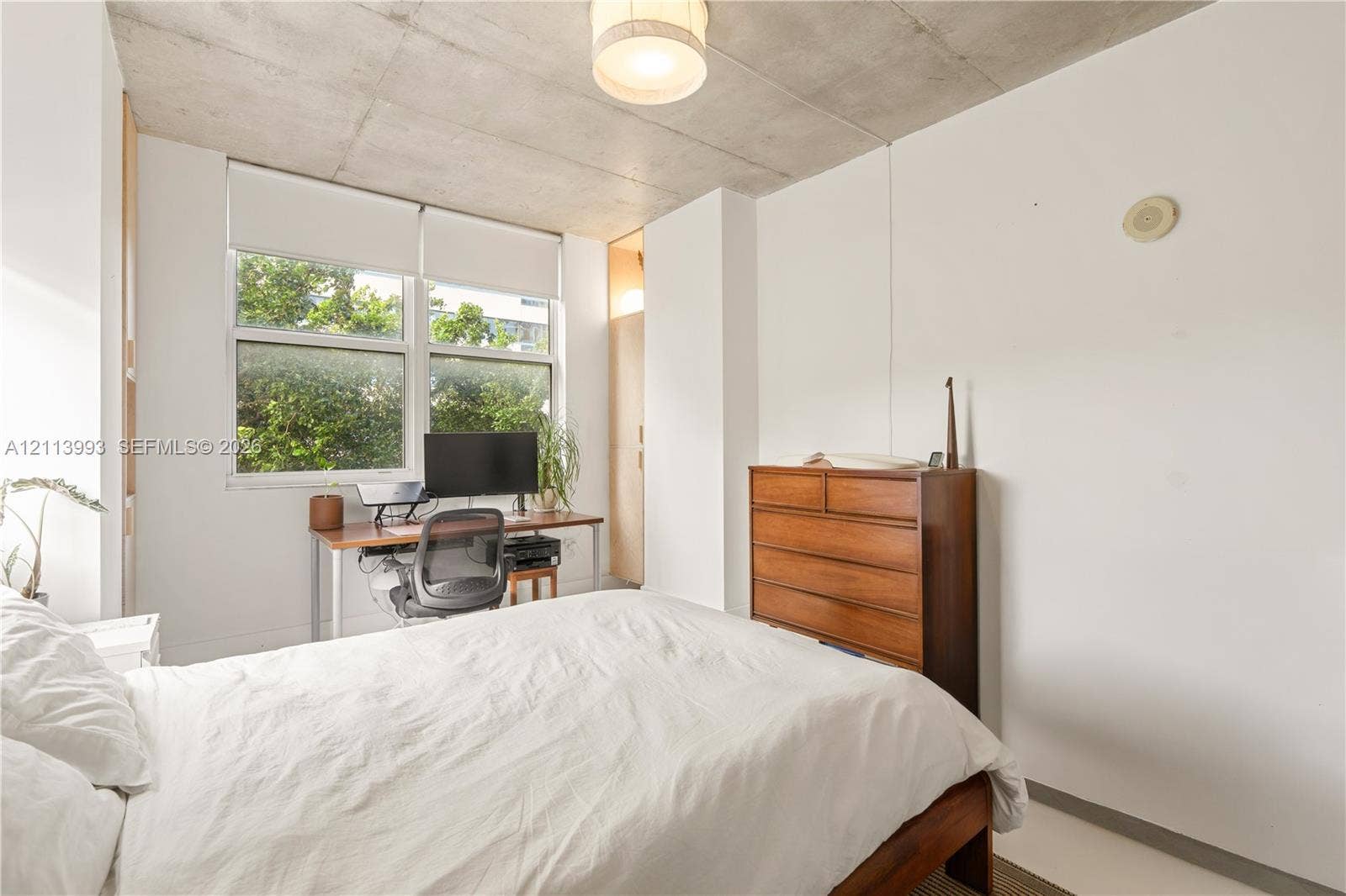 3180 SW 22nd Terrace, #407, Miami, Miami, FL 33145 Exposed concrete ceiling, large multi-pane windows, and built-in closet cabinetry with wood-finish doors