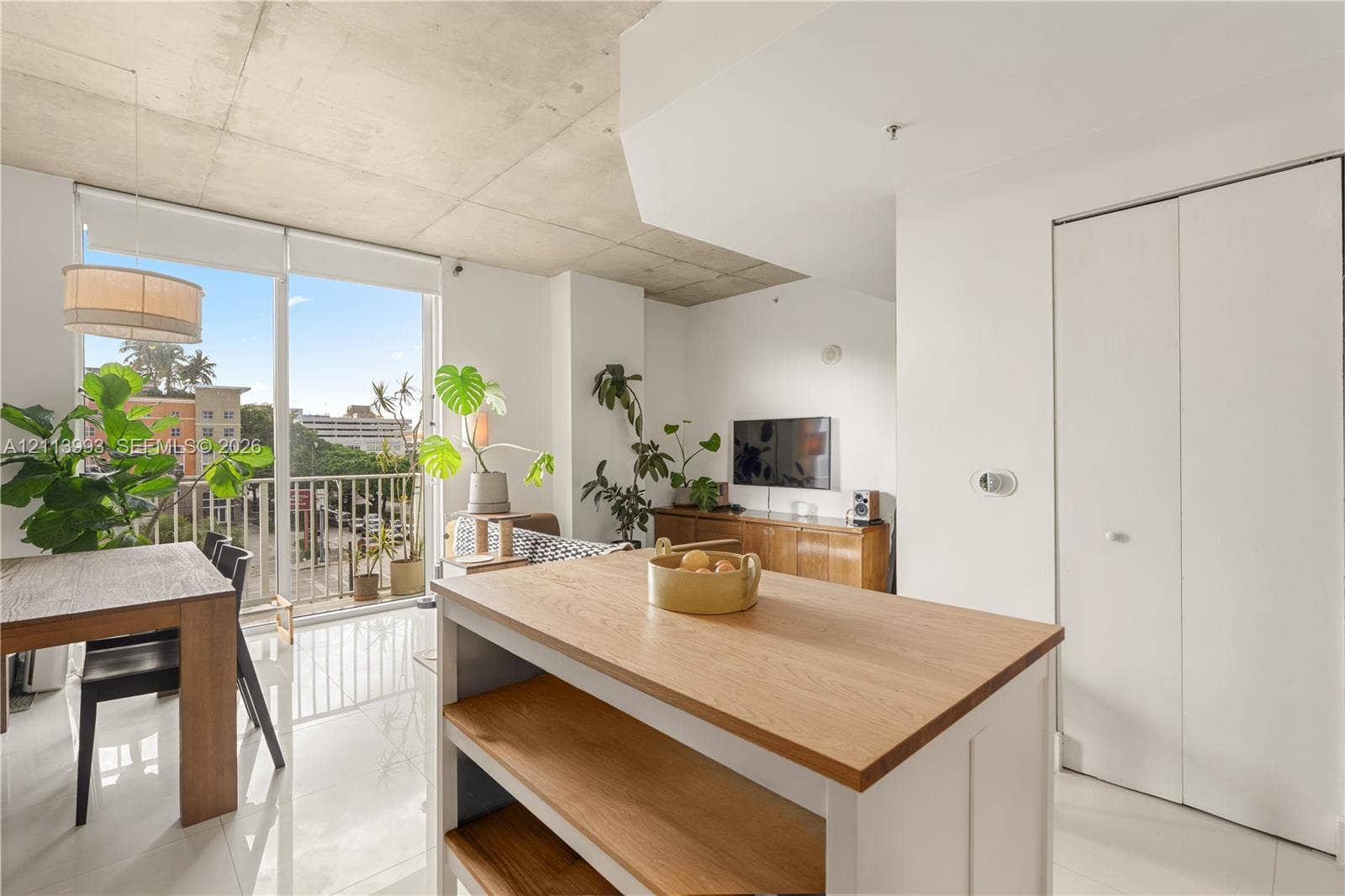3180 SW 22nd Terrace, #407, Miami, Miami, FL 33145 Exposed concrete ceiling, floor-to-ceiling glass door, private balcony, wood-top kitchen island, and polished floor tile