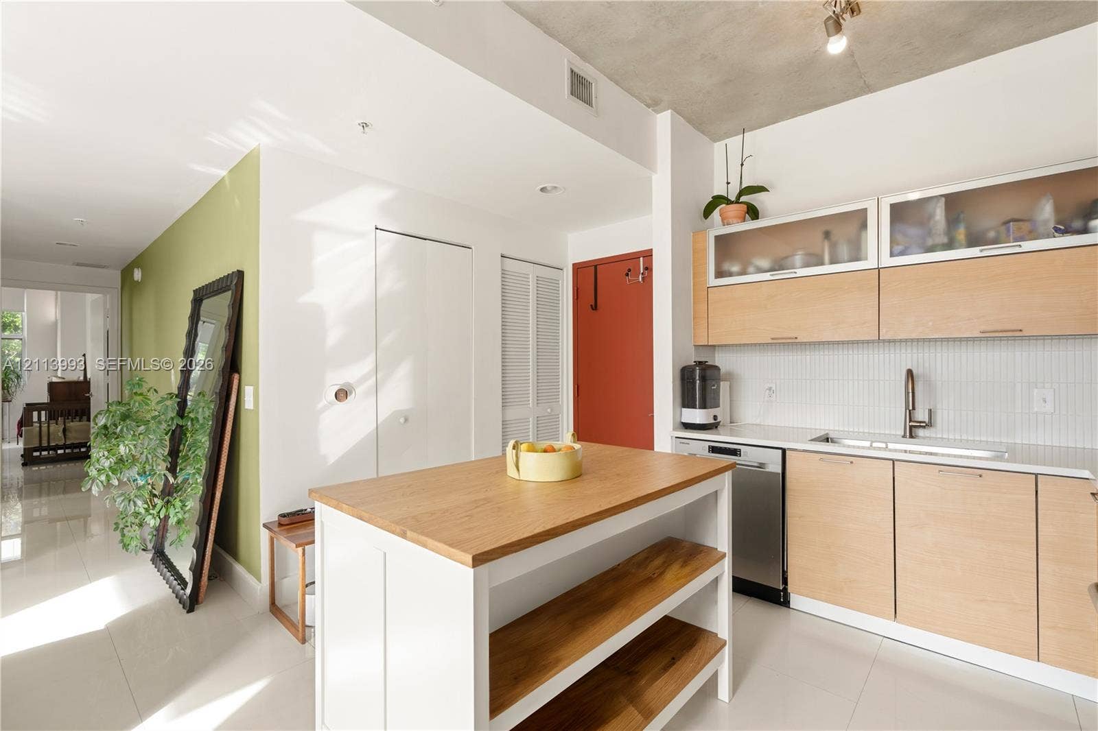 3180 SW 22nd Terrace, #407, Miami, Miami, FL 33145 Kitchen featuring light wood-finish cabinetry, white solid-surface countertops, industrial-style exposed concrete ceiling, tiled backsplash, and a white kitchen island with open wood shelving