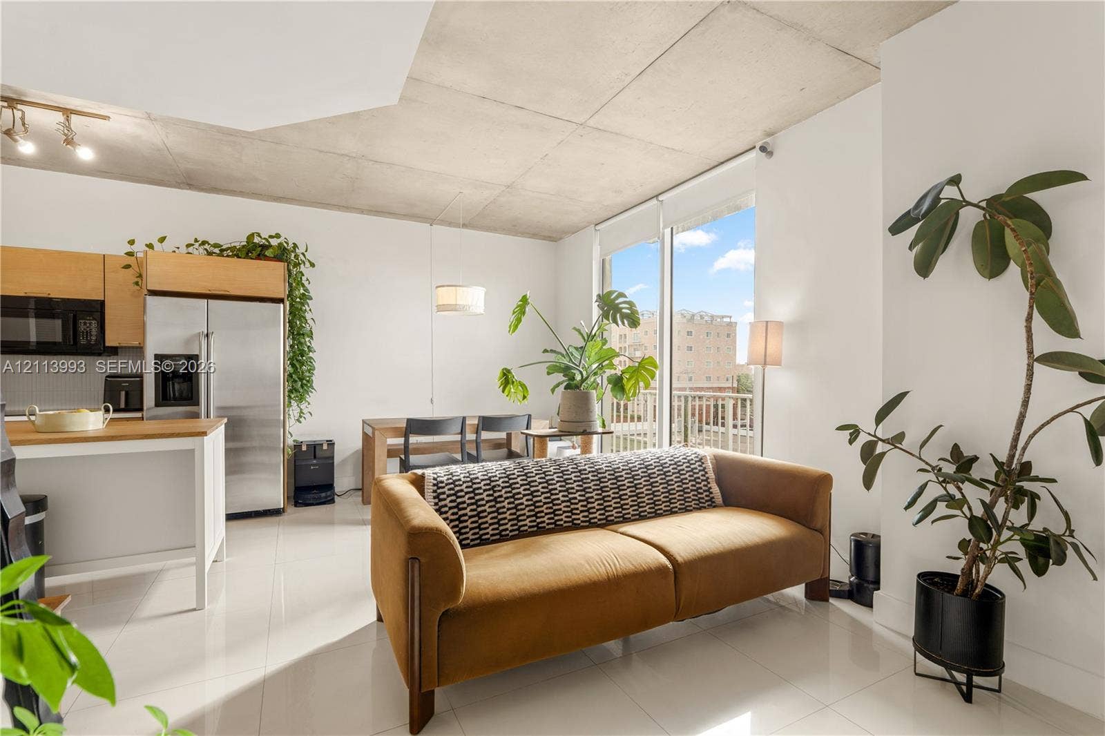 3180 SW 22nd Terrace, #407, Miami, Miami, FL 33145 Exposed concrete ceiling, floor-to-ceiling glass sliding door, polished tile flooring, stainless steel kitchen appliances, and light-toned cabinetry