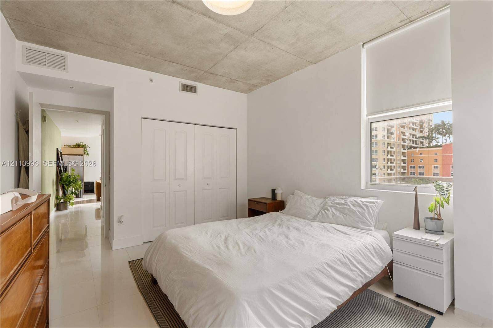 3180 SW 22nd Terrace, #407, Miami, Miami, FL 33145 Exposed concrete ceiling, large window with roller shade, double-door closet, and glossy tile flooring