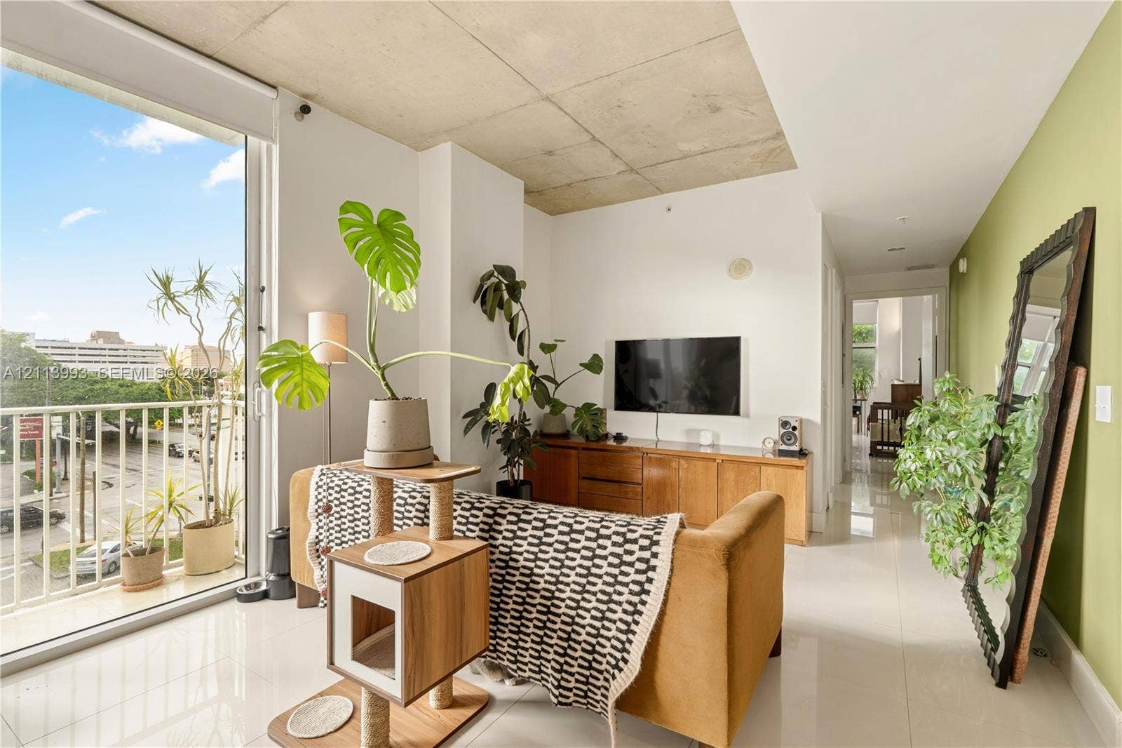 3180 SW 22nd Terrace, #407, Miami, Miami, FL 33145 Exposed concrete ceiling, floor-to-ceiling glass sliding door, balcony with metal railing, and polished tile flooring