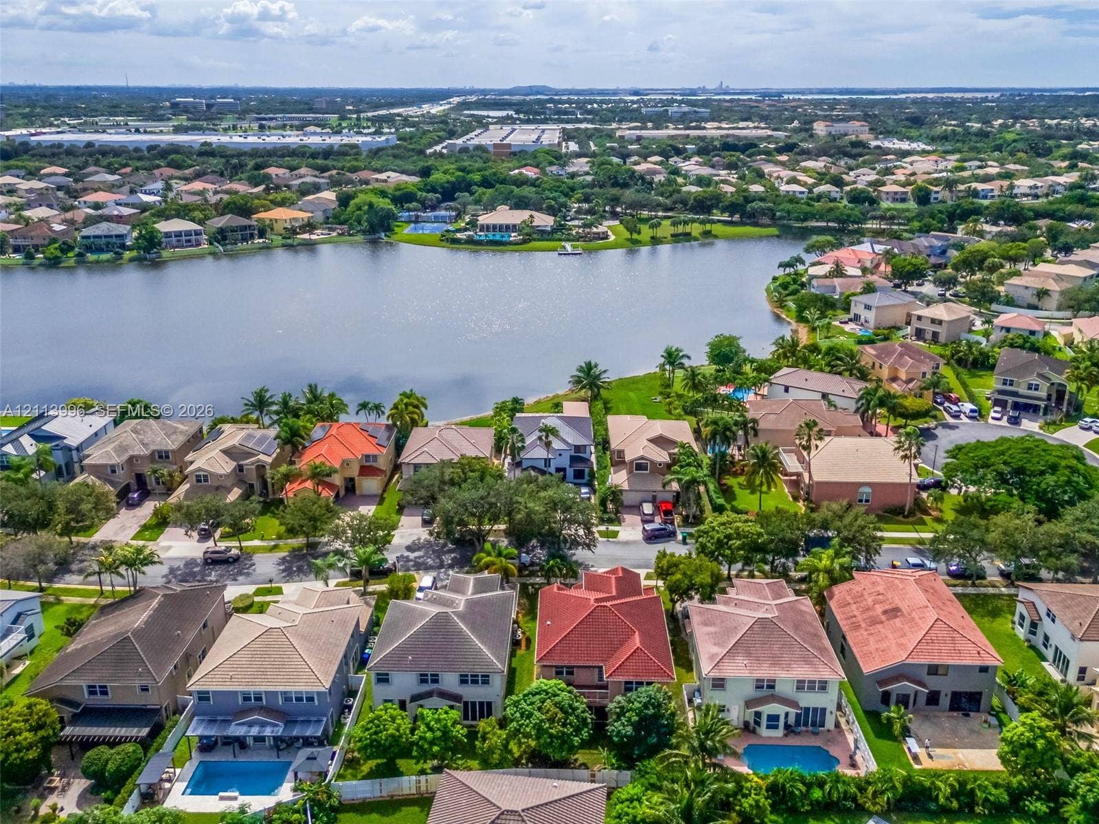 15503 SW 19th Street, Miramar, FL 33027 Aerial perspective featuring waterfront residential properties with multi-pitch rooflines, private swimming pools, paved patio areas, and mature landscaping