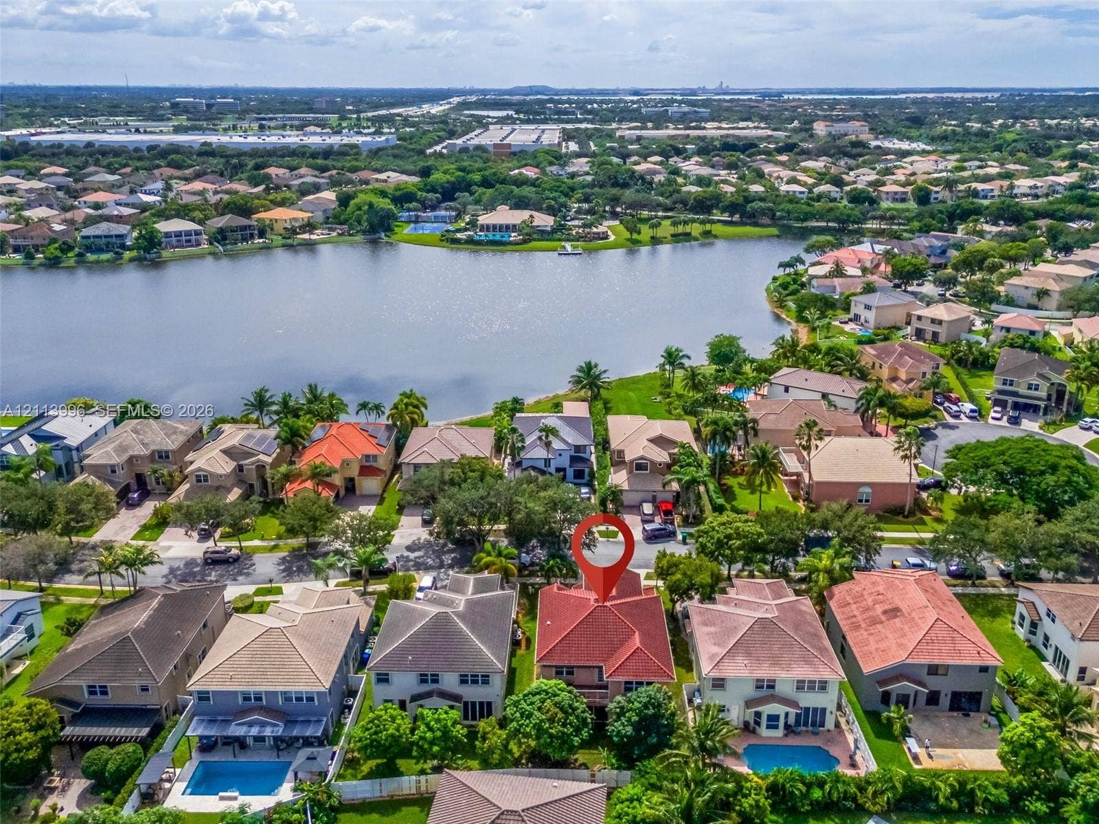15503 SW 19th Street, Miramar, FL 33027 Aerial perspective of a multi-story residence with a multi-gabled tile roof, situated in a suburban community featuring a large lake and mature landscaping