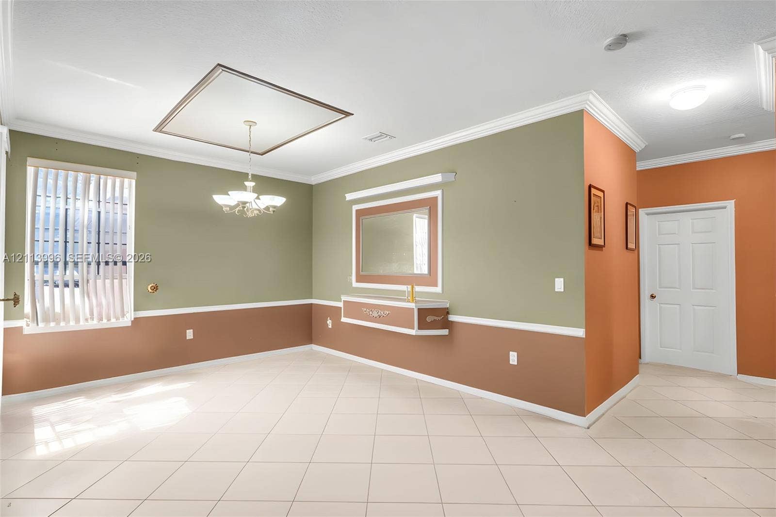15503 SW 19th Street, Miramar, FL 33027 Tile flooring, crown molding, chair rail trim, multi-tiered chandelier, and built-in wall niche with mirror