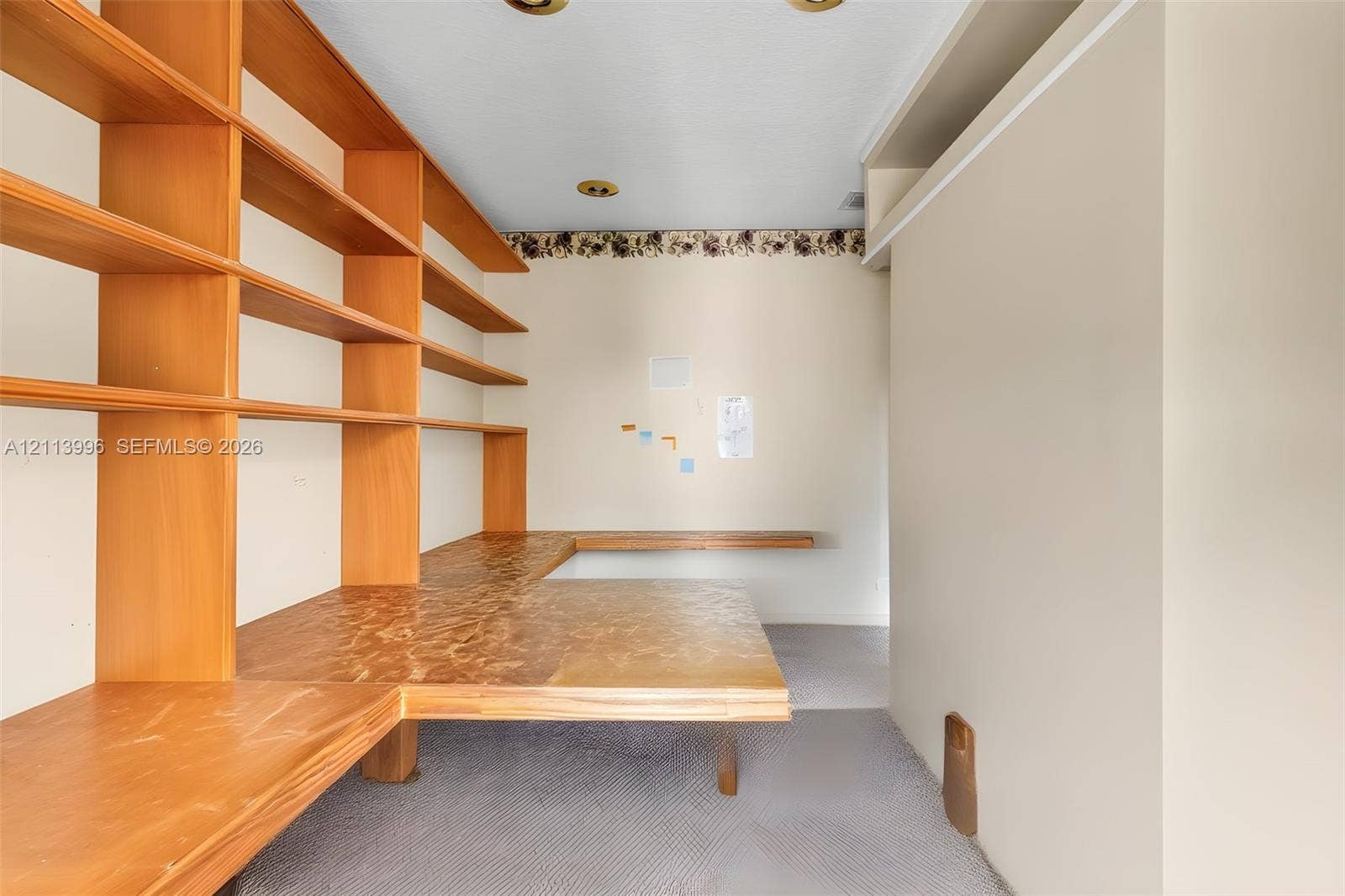 15503 SW 19th Street, Miramar, FL 33027 Built-in L-shaped wood cabinetry featuring floor-to-ceiling shelving and an integrated countertop surface