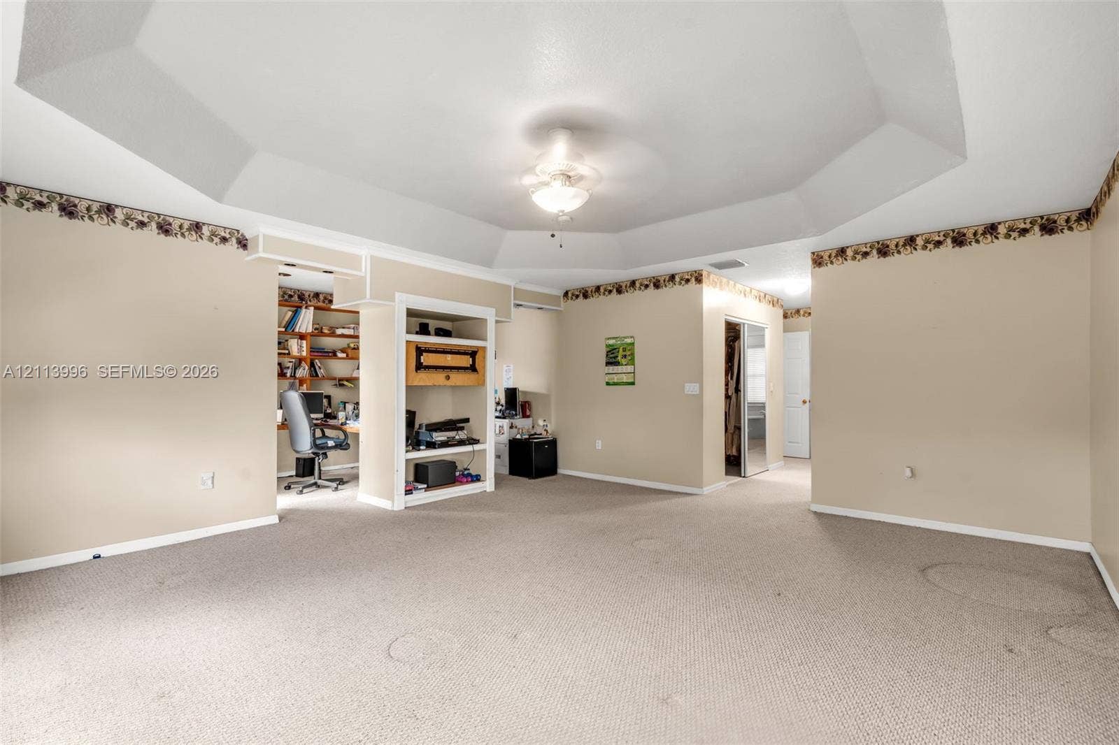 15503 SW 19th Street, Miramar, FL 33027 Tray ceiling with central light fixture, wall-to-wall carpeting, and built-in shelving unit