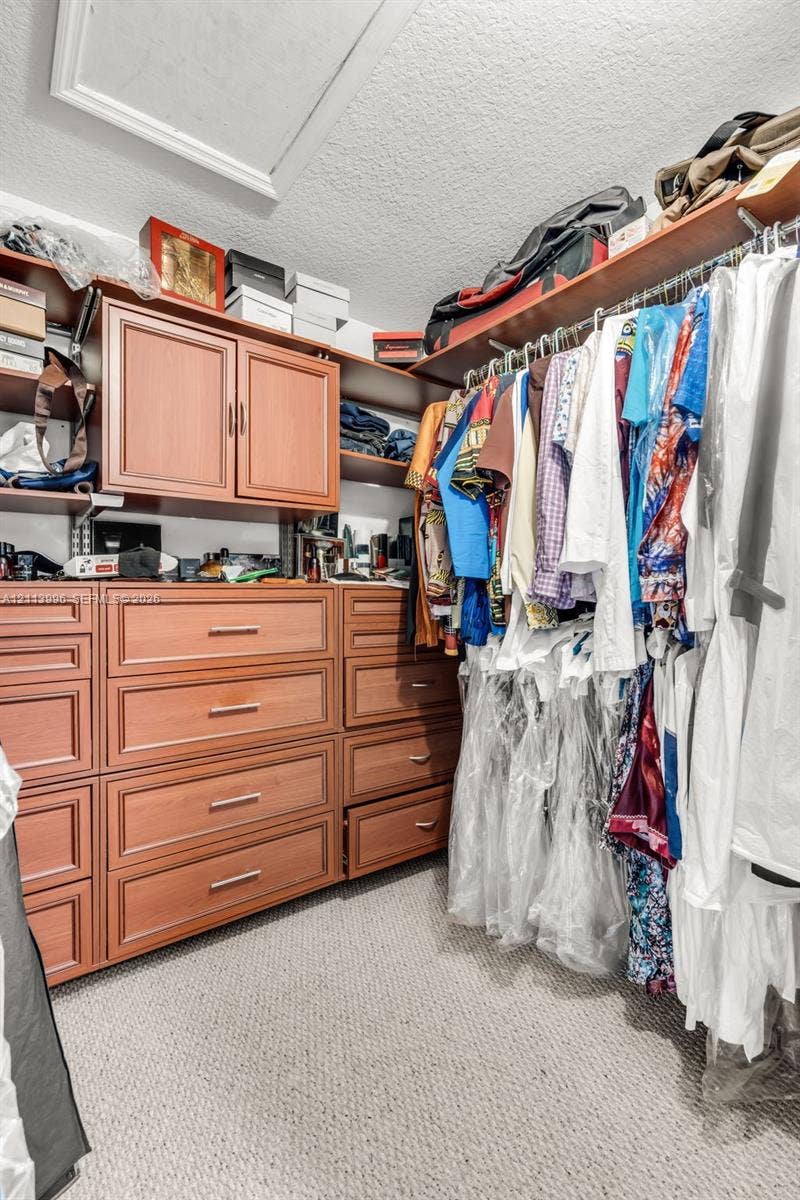 15503 SW 19th Street, Miramar, FL 33027 Custom storage system featuring wood-finish cabinetry, built-in shelving, integrated dresser drawers, and metal clothing rods