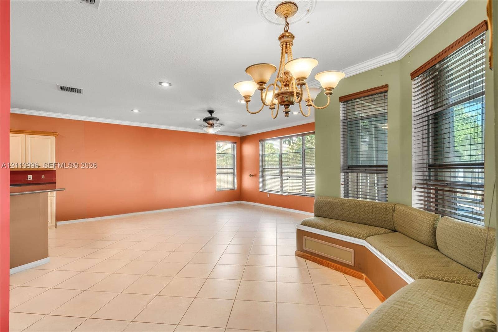 15503 SW 19th Street, Miramar, FL 33027 Open-concept room featuring tile flooring, crown molding, a decorative ceiling medallion with an attached multi-arm chandelier, and a custom built-in bench