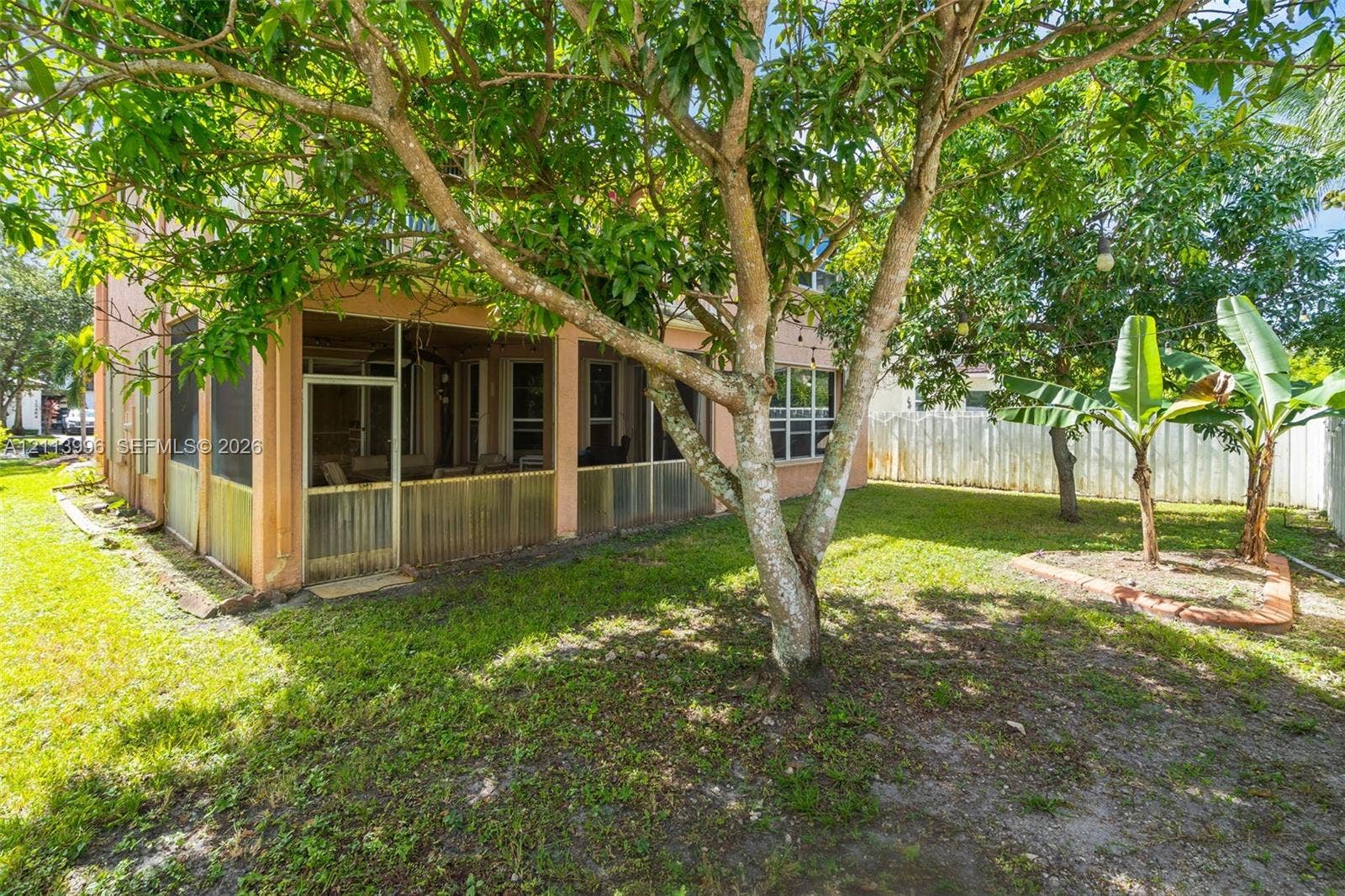 15503 SW 19th Street, Miramar, FL 33027 Screened-in porch featuring a concrete foundation, fenced-in backyard, and mature trees