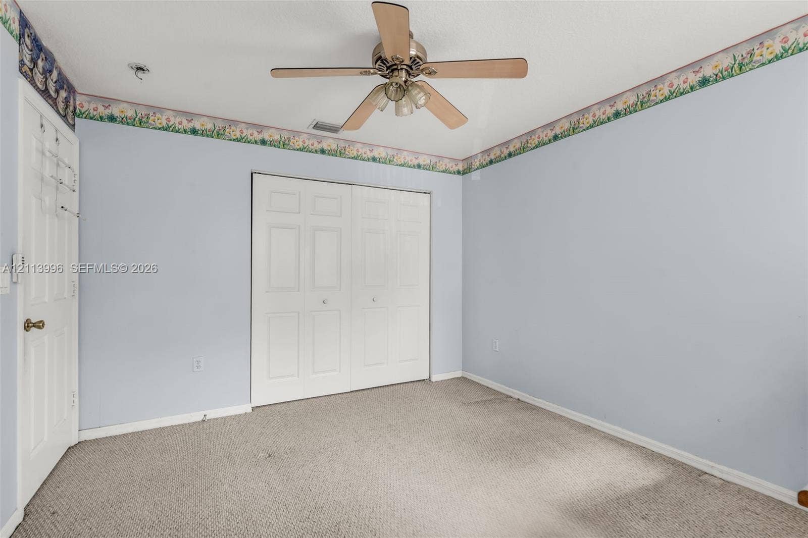 15503 SW 19th Street, Miramar, FL 33027 Room featuring neutral carpeting, a ceiling-mounted fan with integrated lighting, and a double-panel closet with white doors