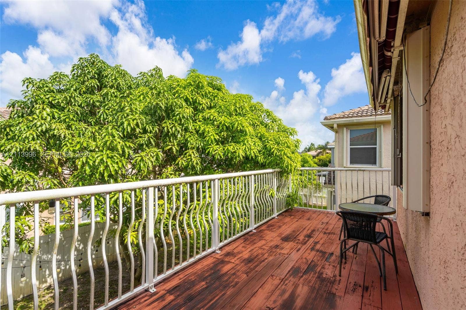 15503 SW 19th Street, Miramar, FL 33027 Exterior balcony featuring wood-finish decking, white metal railing, and stucco wall siding
