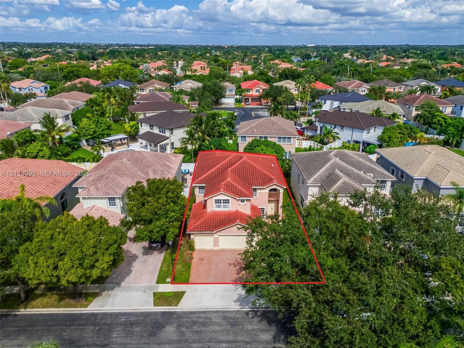 15503 SW 19th Street, Miramar, FL 33027 Two-story stucco exterior featuring a red tile roof, multi-gabled architectural profile, attached garage, and paved driveway