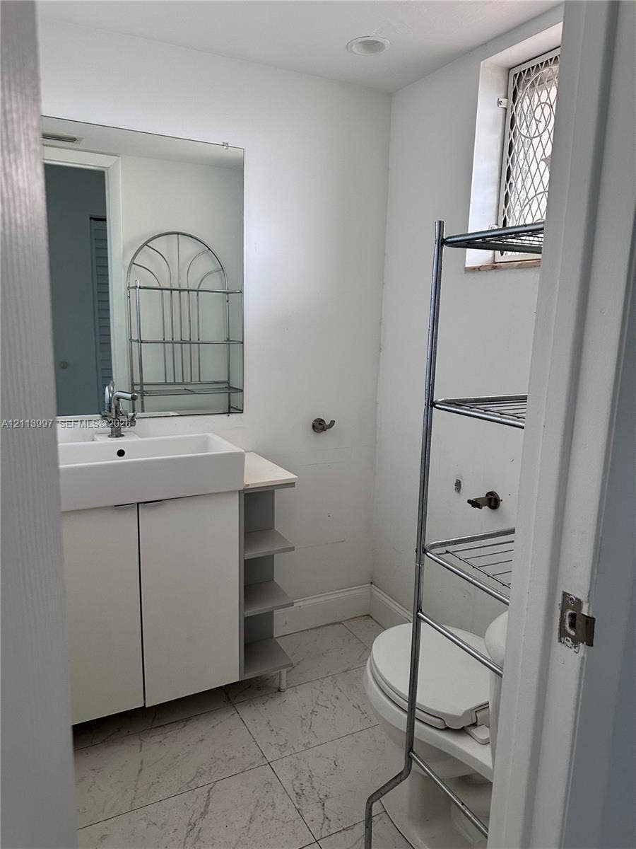 1501 NE 191st Street, #C412, Miami, FL 33179 Bathroom featuring a rectangular vessel sink, vanity with built-in side shelving, large wall-mounted mirror, recessed ceiling lighting, and tile flooring