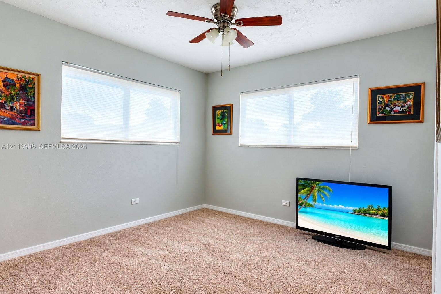 16455 SW 91st Avenue, Palmetto Bay, FL 33157 Neutral-toned walls, wall-to-wall carpeting, dual windows with fitted blinds, and a multi-blade ceiling fan with an integrated light fixture