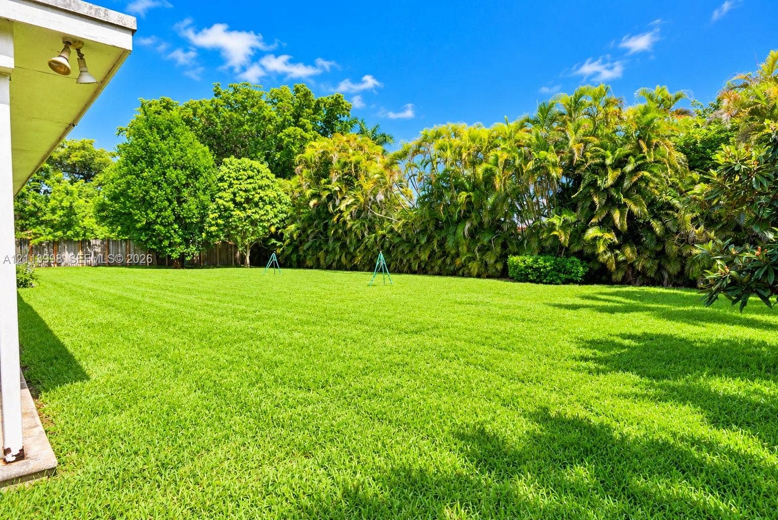 16455 SW 91st Avenue, Palmetto Bay, FL 33157 Expansive backyard featuring a manicured lawn, perimeter fencing, and mature landscaping
