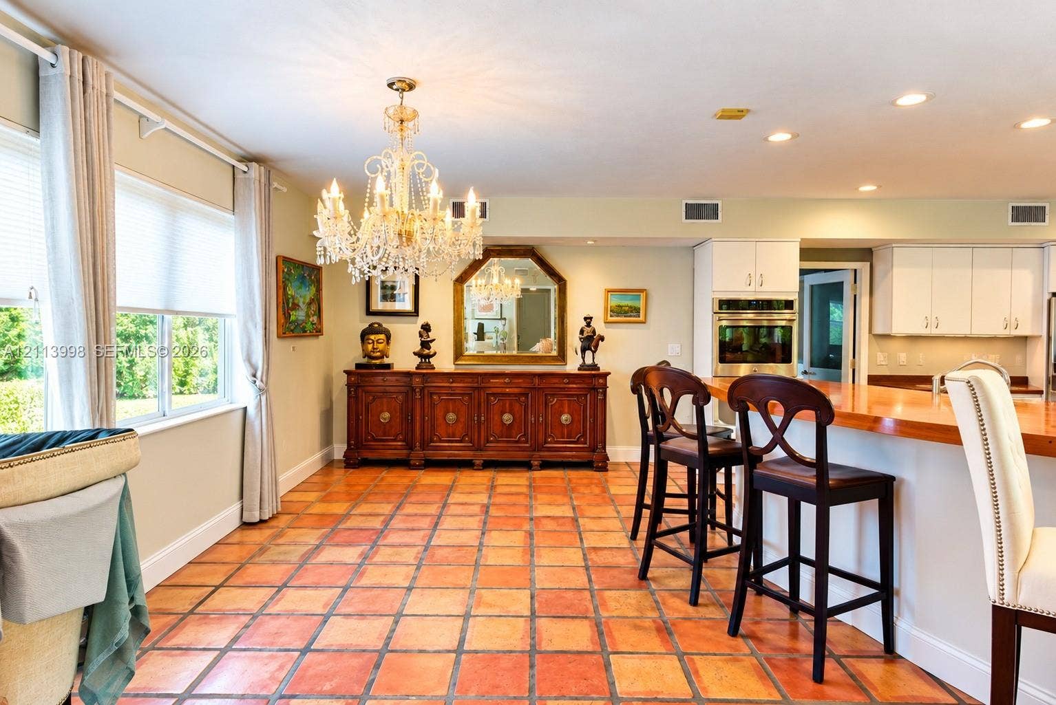 16455 SW 91st Avenue, Palmetto Bay, FL 33157 Tile flooring, tiered crystal chandelier, built-in wooden cabinetry, recessed lighting, and kitchen island with a wood countertop