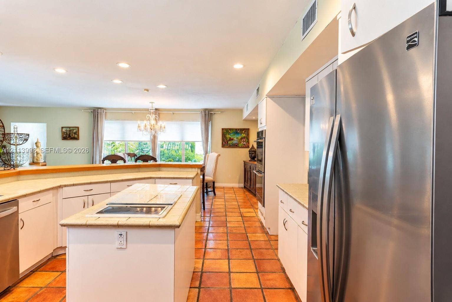 16455 SW 91st Avenue, Palmetto Bay, FL 33157 Kitchen featuring a central island with a tiled countertop, stainless steel refrigerator, white cabinetry, integrated wall oven, and ceramic tile flooring