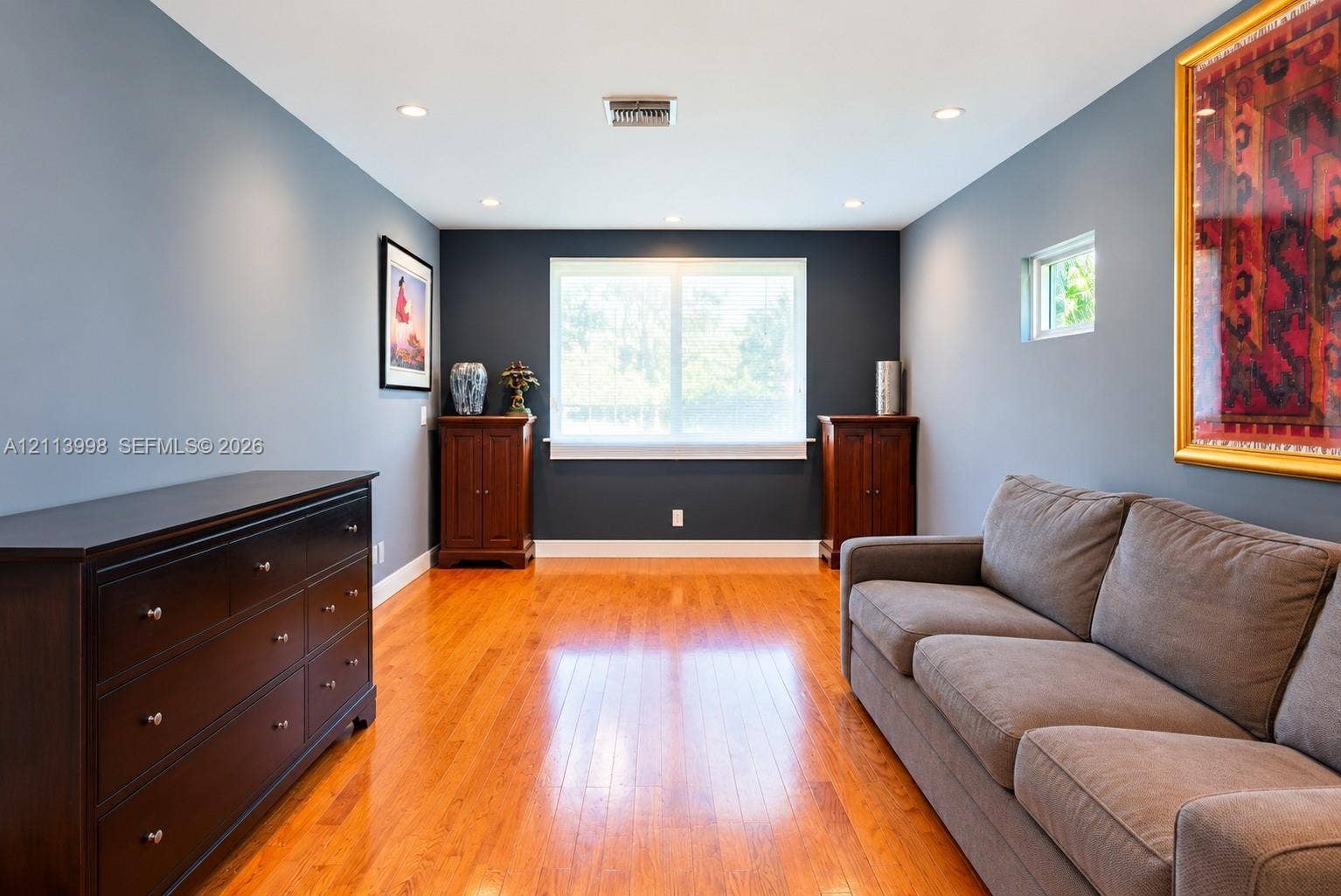 16455 SW 91st Avenue, Palmetto Bay, FL 33157 Room featuring wood-finish flooring, recessed lighting, and a neutral color palette with a dark accent wall