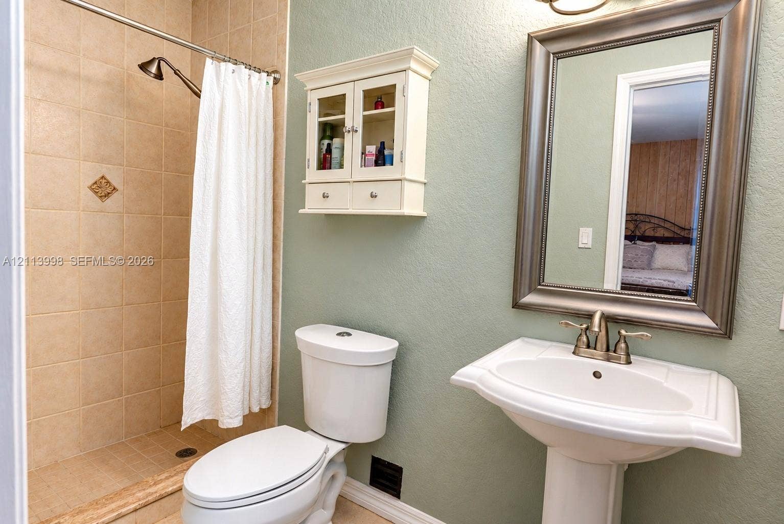 16455 SW 91st Avenue, Palmetto Bay, FL 33157 Pedestal sink with metallic faucet, wall-mounted cabinet, and tile-surround shower