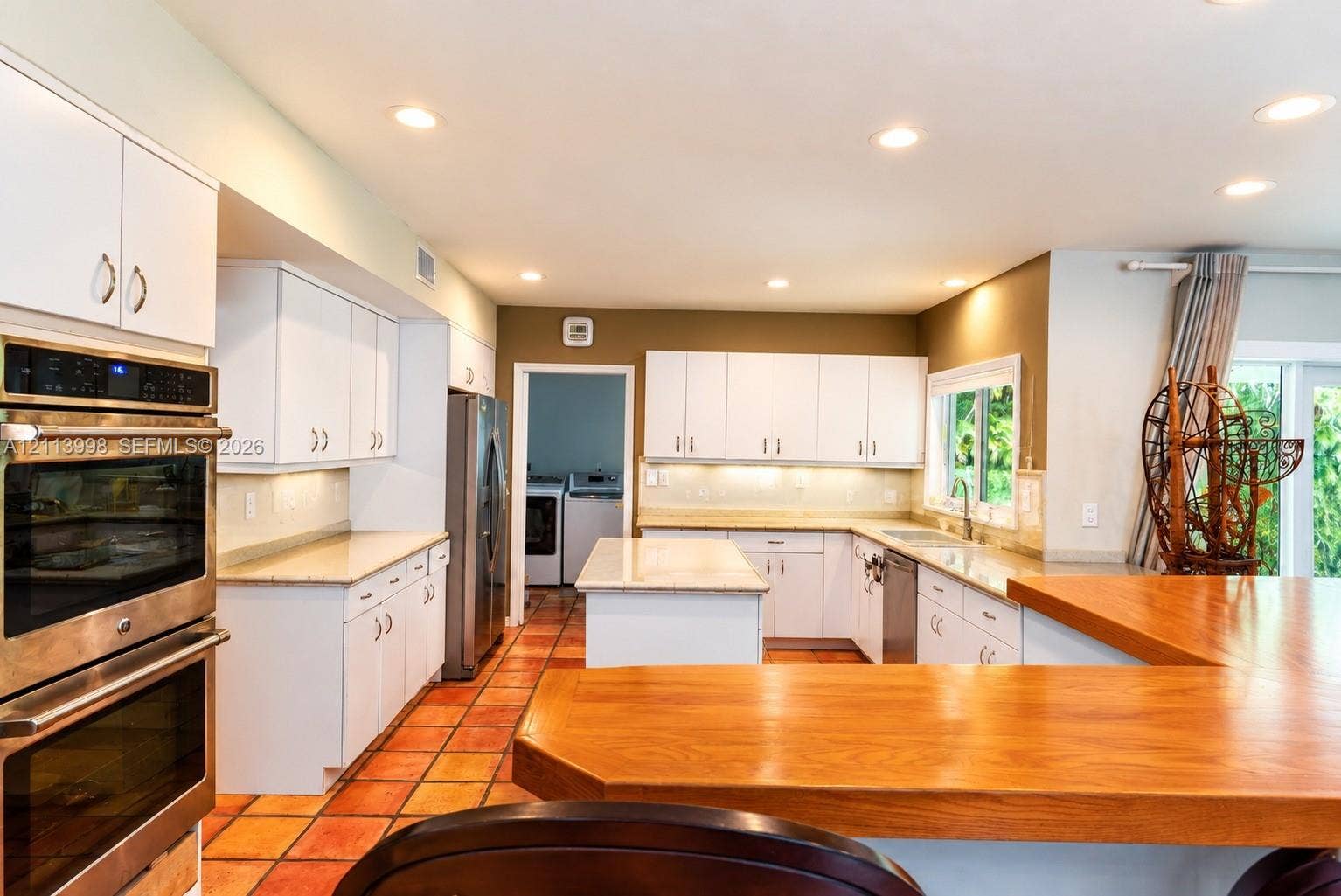 16455 SW 91st Avenue, Palmetto Bay, FL 33157 Kitchen featuring white cabinetry, stone-finish countertops, stainless steel double wall ovens, a center island, and ceramic tile flooring
