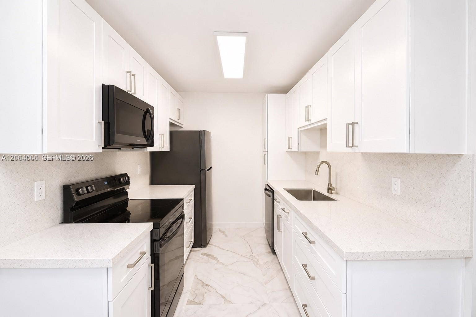 2611 SW 13th Avenue, #1-2, Fort Lauderdale, Fort Lauderdale, FL 33315 Galley kitchen featuring white Shaker-style cabinetry, solid-surface countertops, black appliances, a stainless steel undermount sink, and stone-finish tile flooring