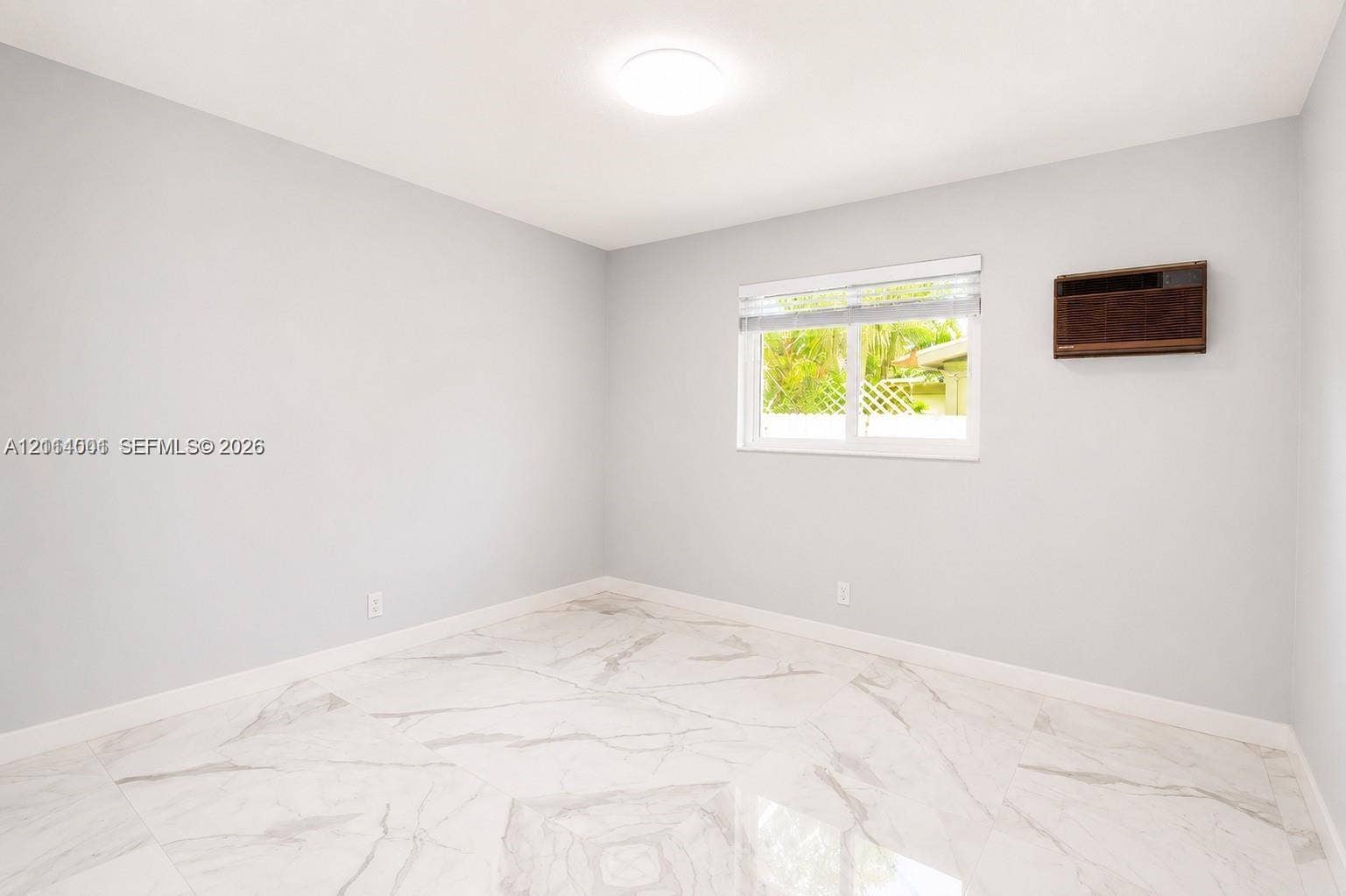 2611 SW 13th Avenue, #1-2, Fort Lauderdale, Fort Lauderdale, FL 33315 Room featuring large-format light-toned stone-finish flooring, neutral wall paint, a ceiling-mounted light fixture, and a window with horizontal blinds
