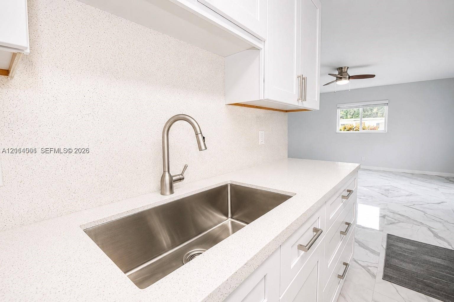2611 SW 13th Avenue, #1-2, Fort Lauderdale, Fort Lauderdale, FL 33315 Stainless steel undermount sink with a gooseneck pull-down faucet, quartz countertops, white shaker-style cabinetry, and polished stone-finish flooring