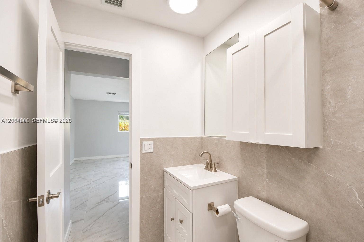 2611 SW 13th Avenue, #1-2, Fort Lauderdale, Fort Lauderdale, FL 33315 Bathroom featuring a white vanity cabinet with an integrated sink, brushed nickel faucet, wall-mounted medicine cabinet, and full-height stone-finish wall tile