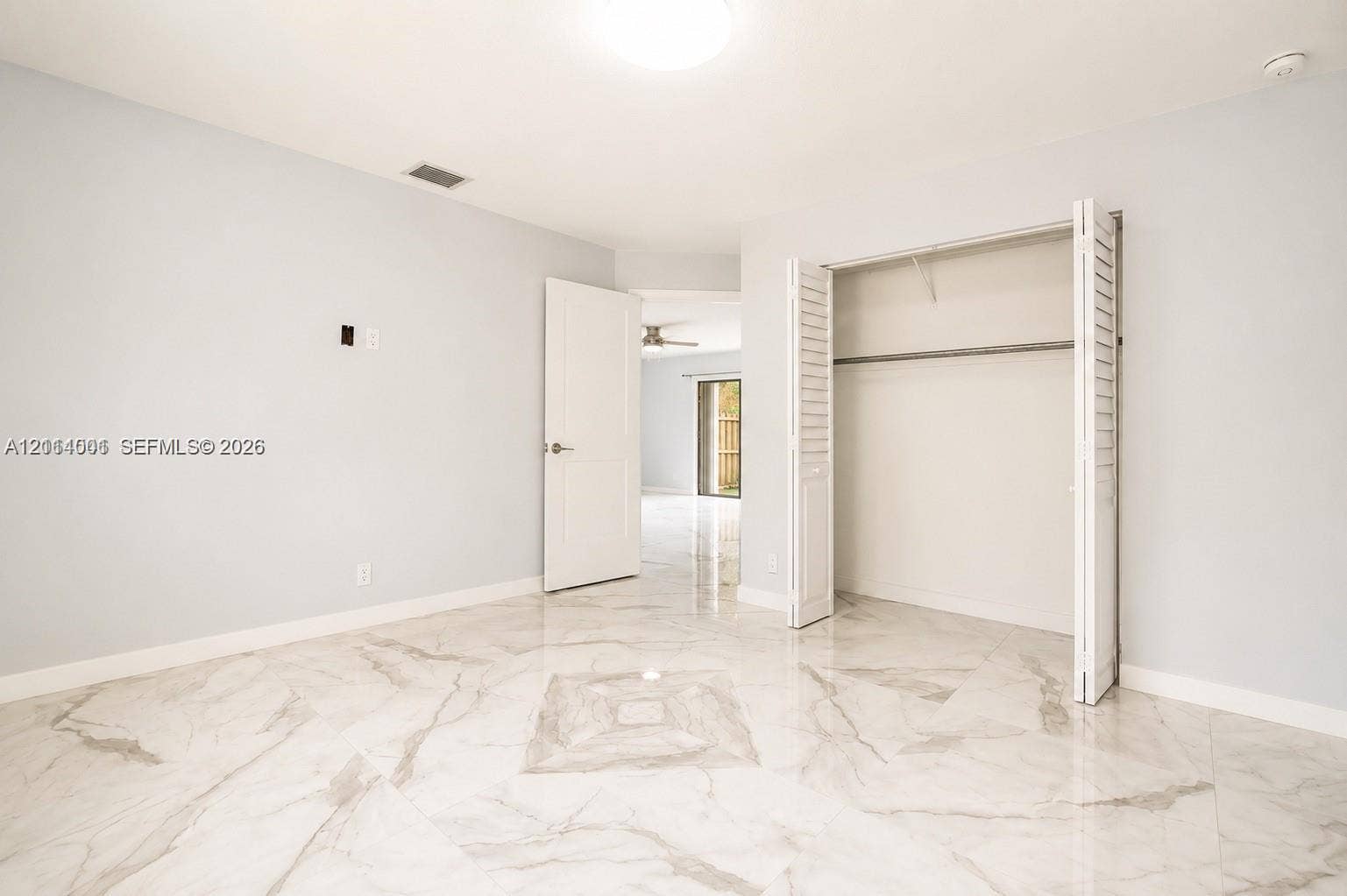 2611 SW 13th Avenue, #1-2, Fort Lauderdale, Fort Lauderdale, FL 33315 Neutral-toned interior featuring large-format polished tile flooring, white bi-fold closet doors, and a solid-core interior door