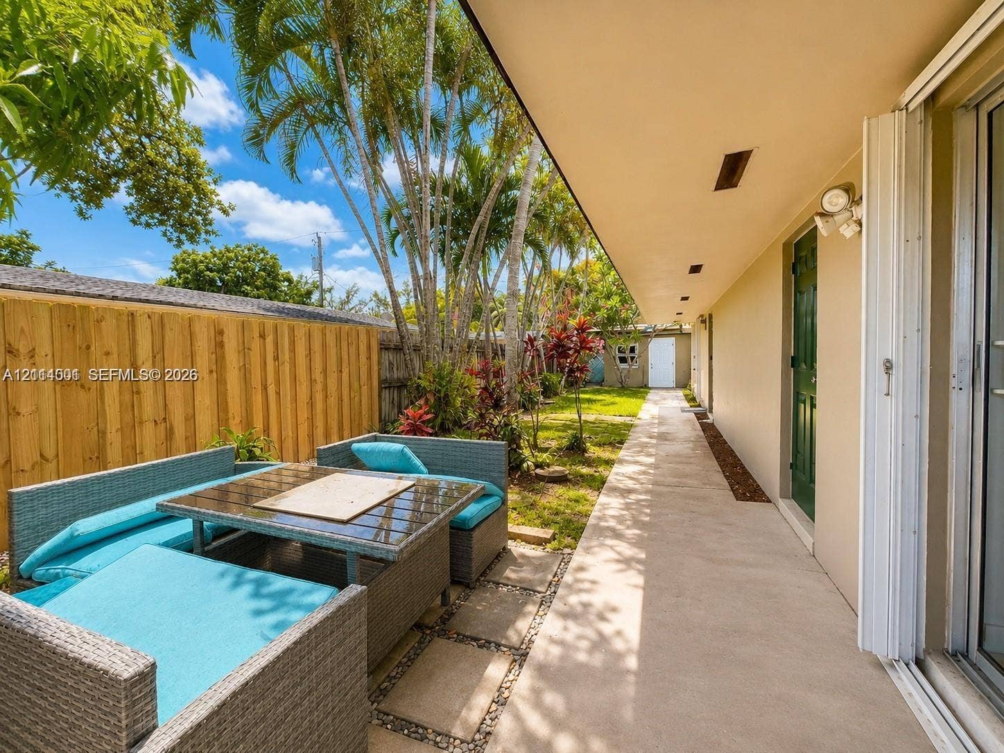 2611 SW 13th Avenue, #1-2, Fort Lauderdale, Fort Lauderdale, FL 33315 Concrete patio featuring a vertical wood fence, stone paver accents, and mature landscaping