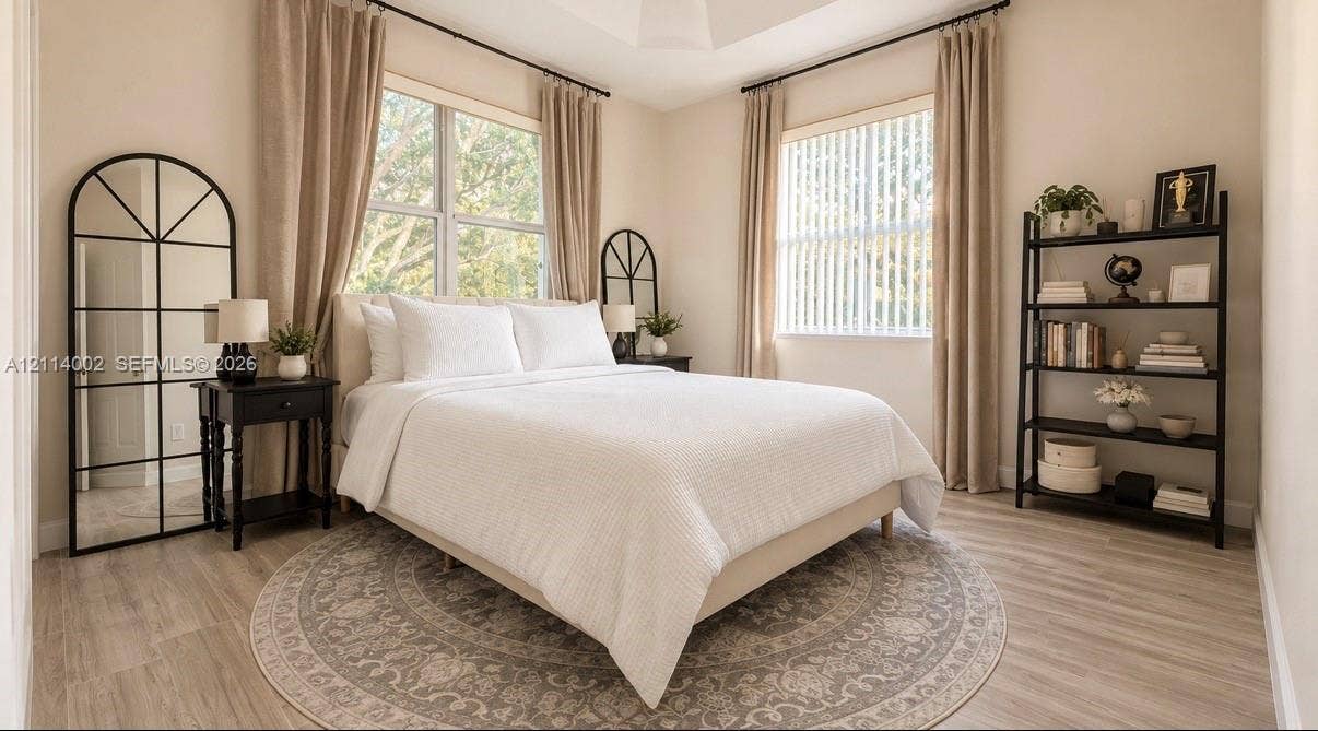 1495 NE 33rd Avenue, #107, Homestead, Homestead, FL 33033 Tray ceiling, wood-finish flooring, and multiple large windows with neutral-toned treatments