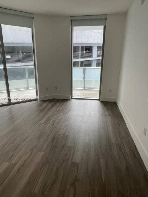 1300 Brickell Bay Drive, #1000, Miami, Miami, FL 33131 Floor-to-ceiling windows, wood-finish flooring, and access to a balcony with metal railing
