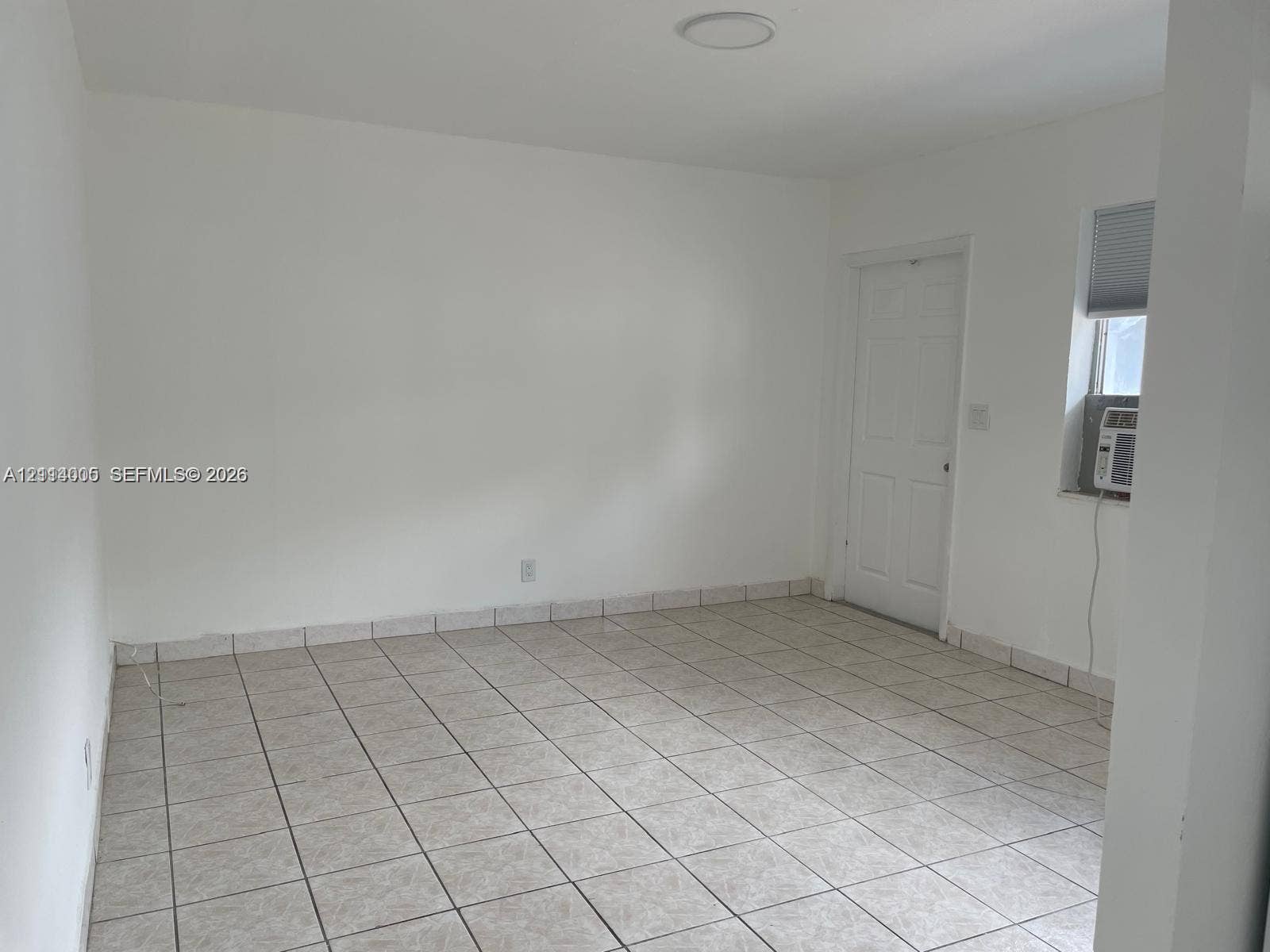 6025 Polk Street, #7, Hollywood, Hollywood, FL 33024 Neutral interior featuring ceramic tile flooring, a six-panel door, and a single-hung window with a recessed mounting