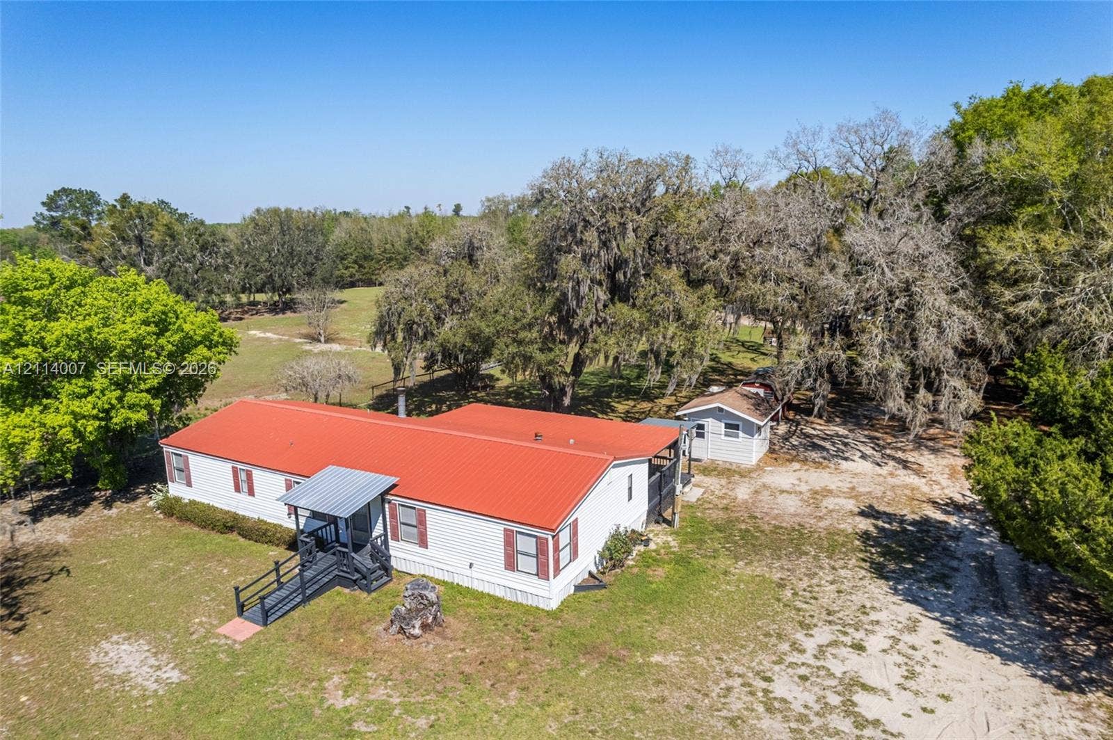 5600 SE 39th Street, Trenton, FL 32693 Exterior featuring a metal roof, white siding, and a dedicated ramped entry