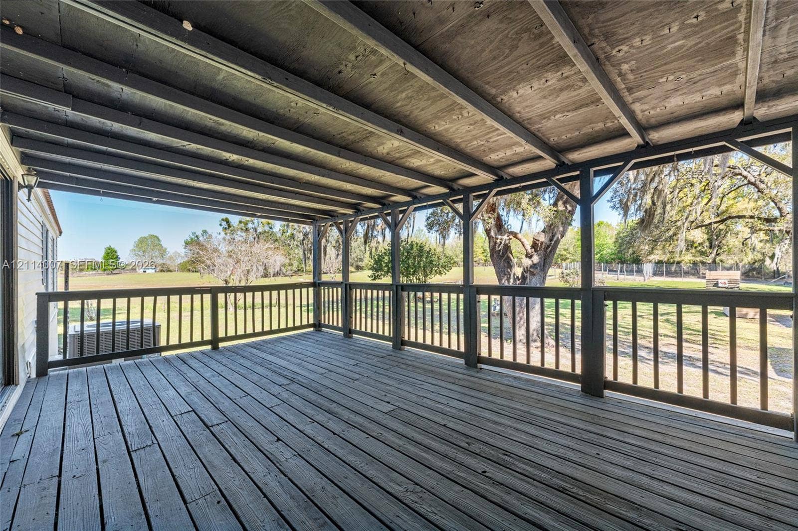 5600 SE 39th Street, Trenton, FL 32693 Covered deck featuring wood-finish flooring, an exposed beam ceiling, and surrounding wooden railing