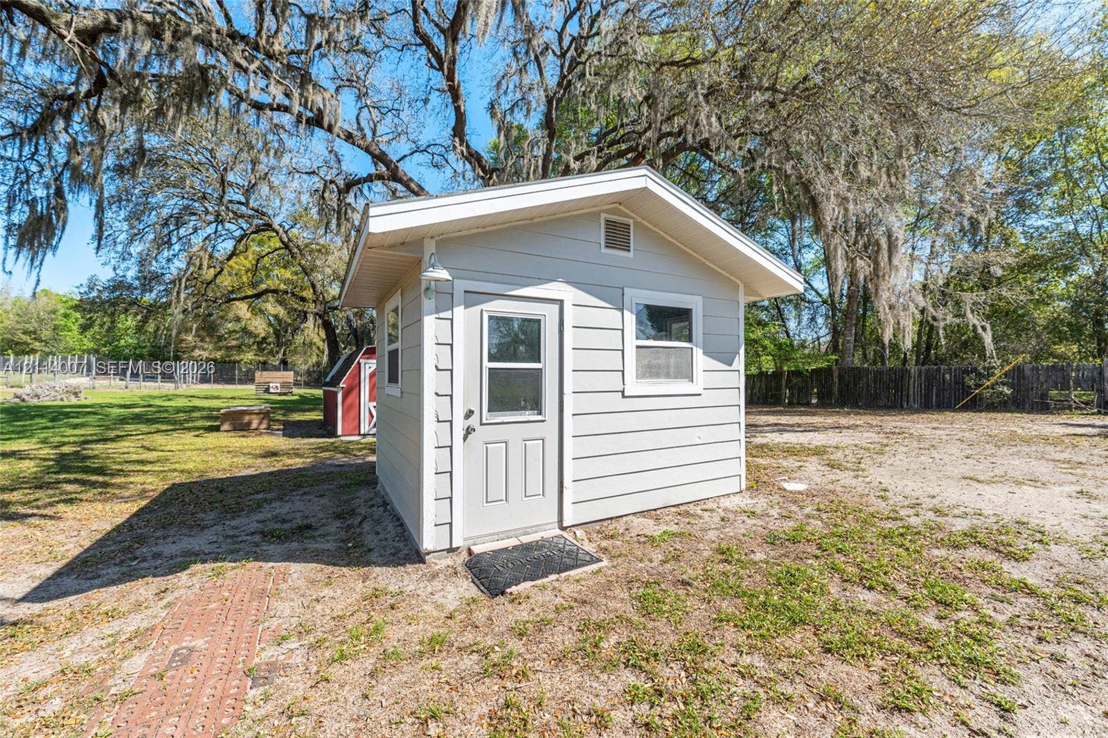 5600 SE 39th Street, Trenton, FL 32693 Detached storage shed featuring light-colored horizontal siding, a gabled roof, and two windows
