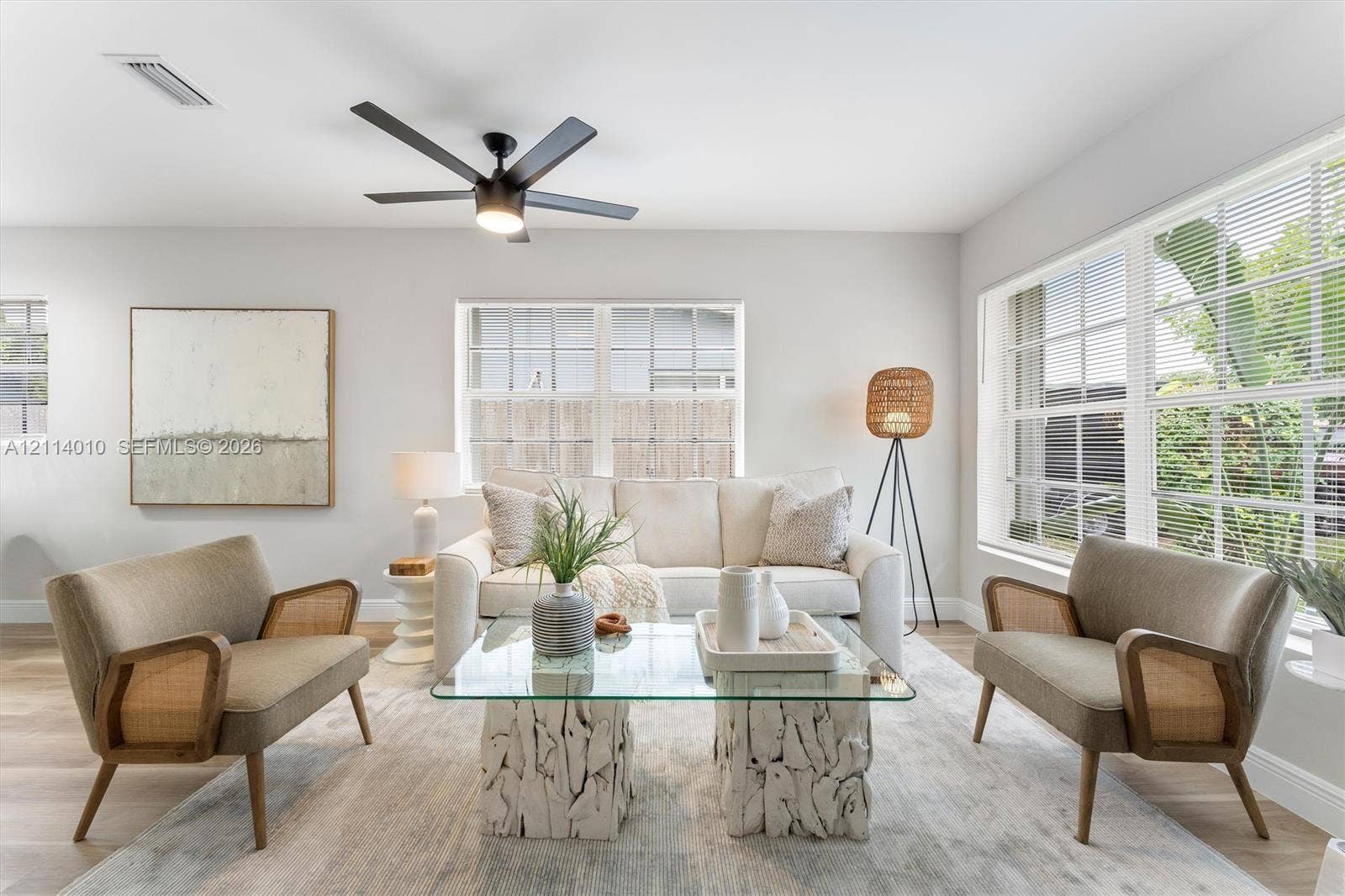 1161-1163 SW 30th Street, Fort Lauderdale, FL 33315 Light-filled interior featuring expansive multi-pane windows, wood-finish flooring, and a central matte black ceiling fan with integrated lighting