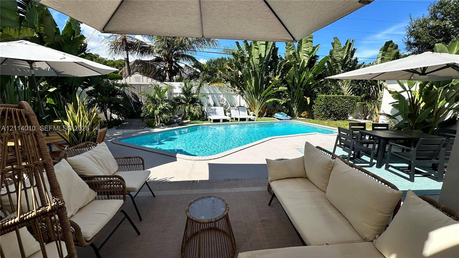 1161-1163 SW 30th Street, Fort Lauderdale, FL 33315 Outdoor living area featuring a concrete patio, swimming pool with concrete surround, and tropical landscaping
