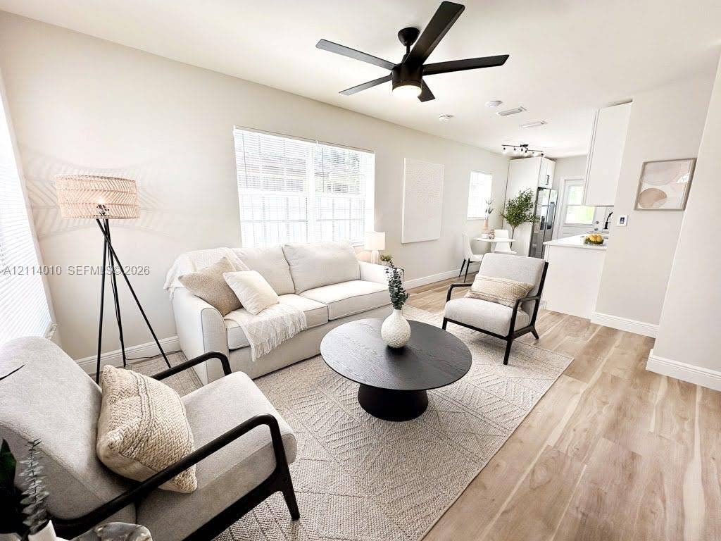 1161-1163 SW 30th Street, Fort Lauderdale, FL 33315 Open-concept interior featuring light wood-finish flooring, recessed lighting, matte black ceiling fan with integrated lighting, and white cabinetry