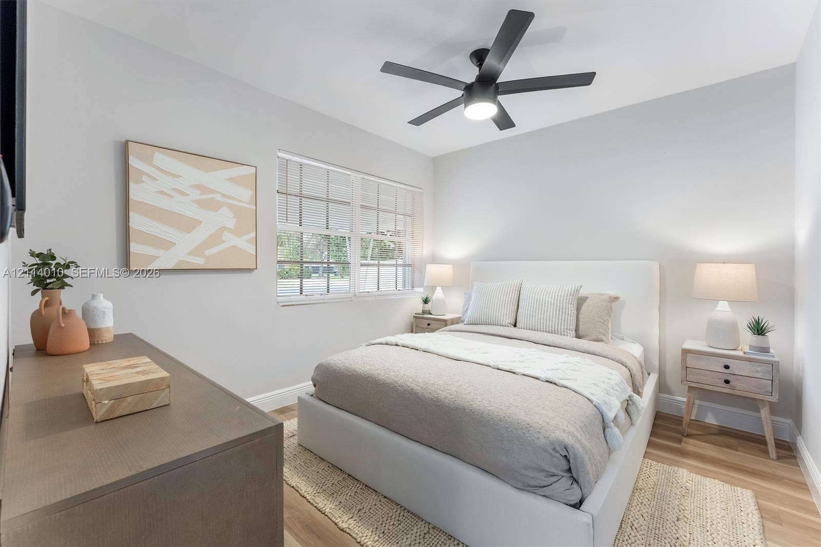 1161-1163 SW 30th Street, Fort Lauderdale, FL 33315 Multi-pane window, wood-finish flooring, and matte black five-blade ceiling fan with integrated lighting