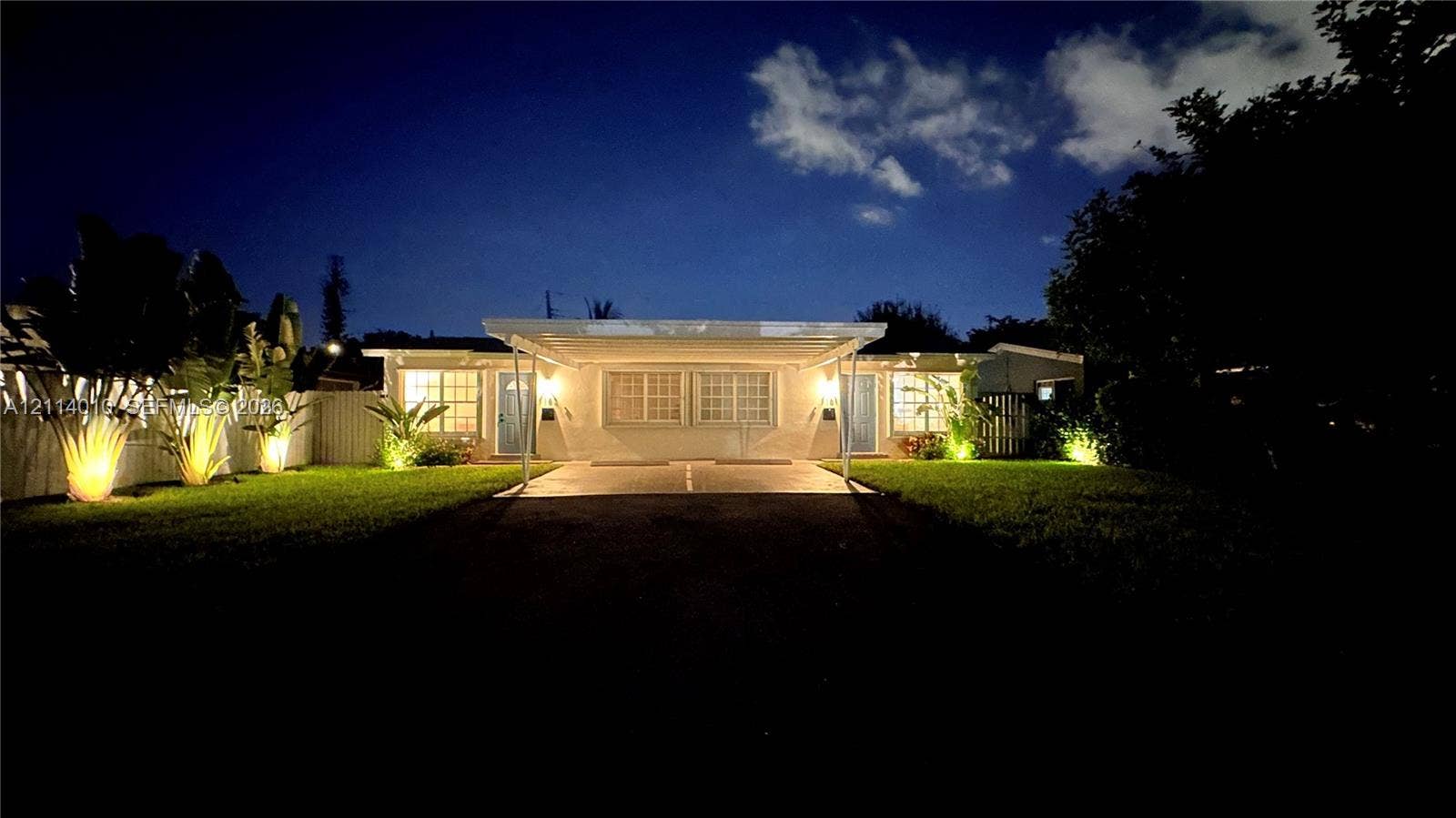 1161-1163 SW 30th Street, Fort Lauderdale, FL 33315 Single-story residence featuring a paved driveway, attached carport, grid-pattern windows, and landscaped front lawn